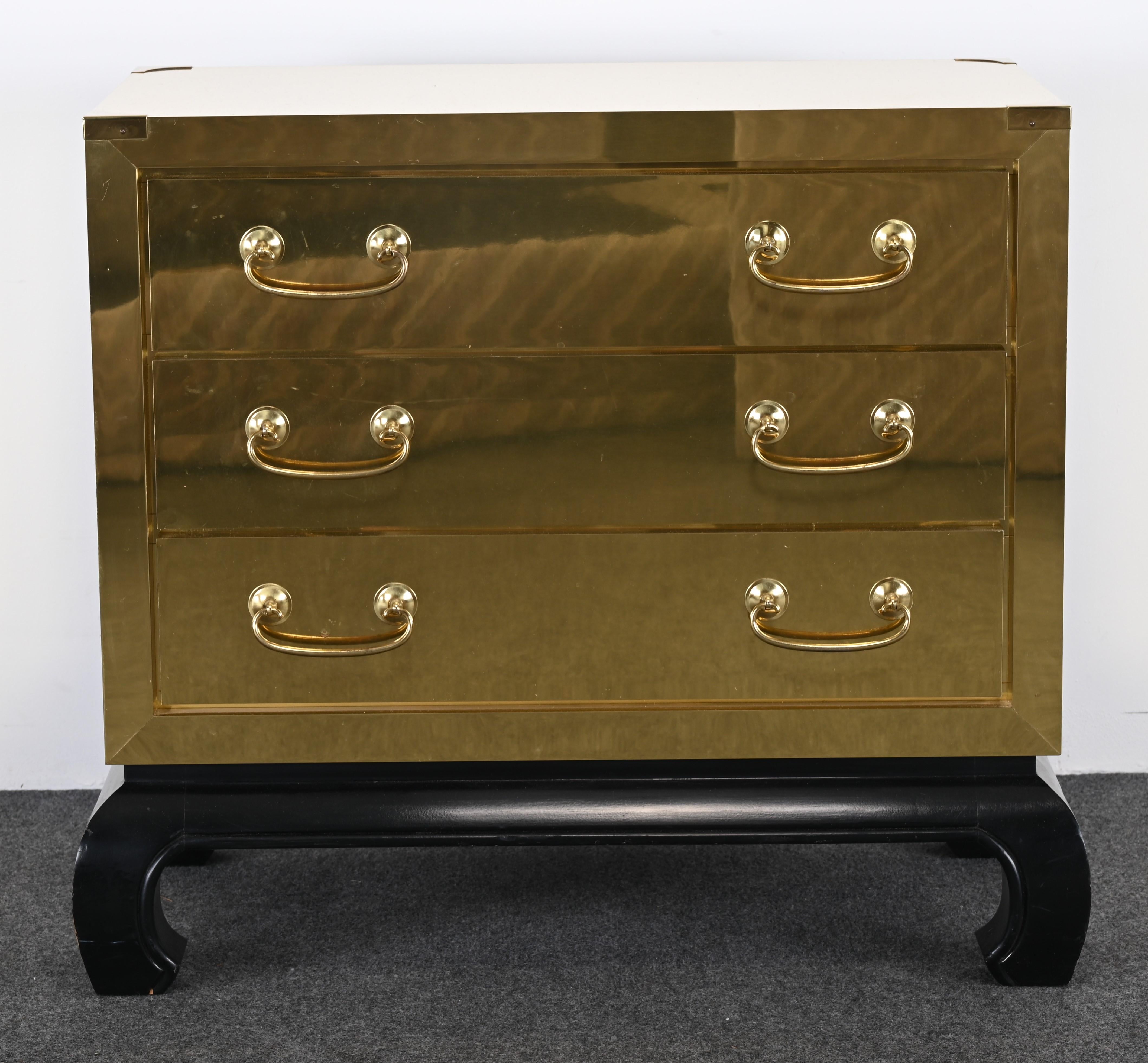 A handsome Brass Clad Asian style chest of drawers in the manner of Sarreid, LTD. This distinctive brass chest would add a touch of glamour or elegance to any interior. It would look great with Mid-Century Modern or Traditional. Brass handles are