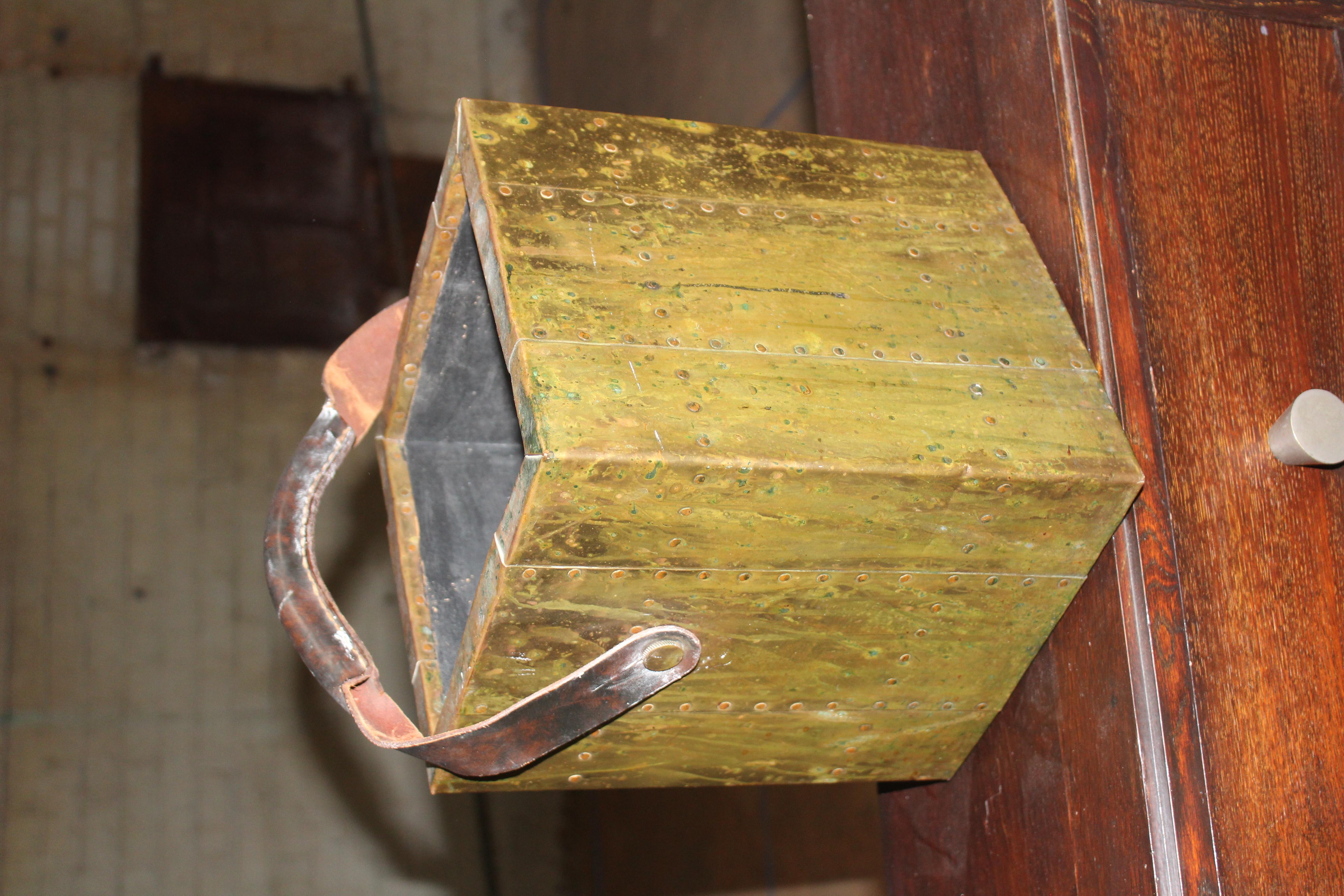 A vintage brass glad box or waste paper basket by Sarreid of Spain. With a leather handle. Shows age appropriate wear and patina.