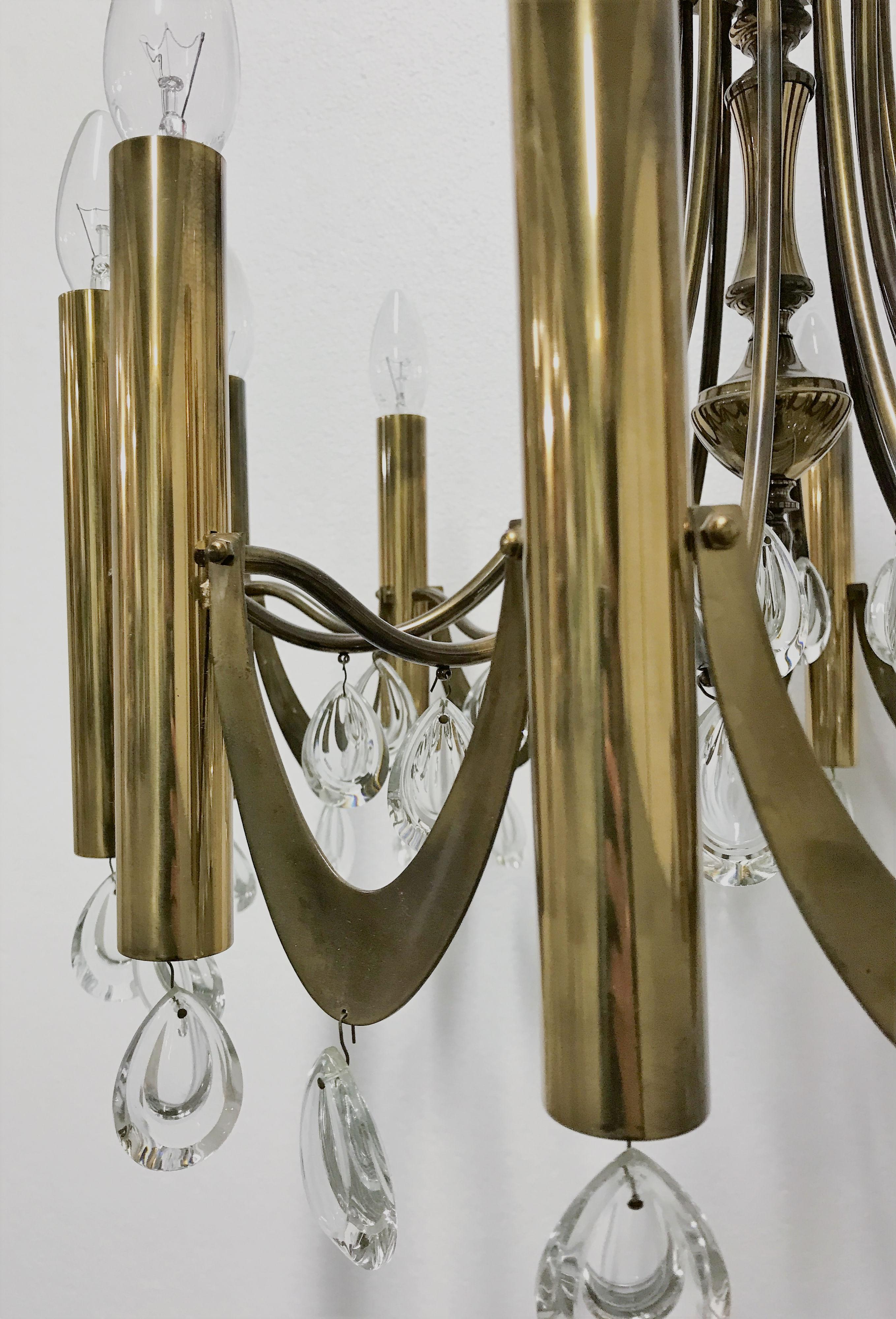 Stupendo lampadario di Gaetano Sciolari della metà del secolo scorso.

Questa lampada ha un design più classico con dodici punti luce a candela e prismi di cristallo.

Il lampadario avrà un aspetto più 