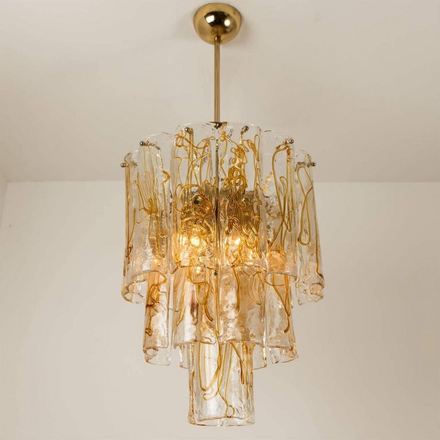 A stunning and high quality masterpiece chandelier by Doria, 1970. It features Murano 23 blown art glass prisms on a brass structure.
The prims refract light beautifully and are perfect for a soft, warm and welcoming glow in the room.

Measures: