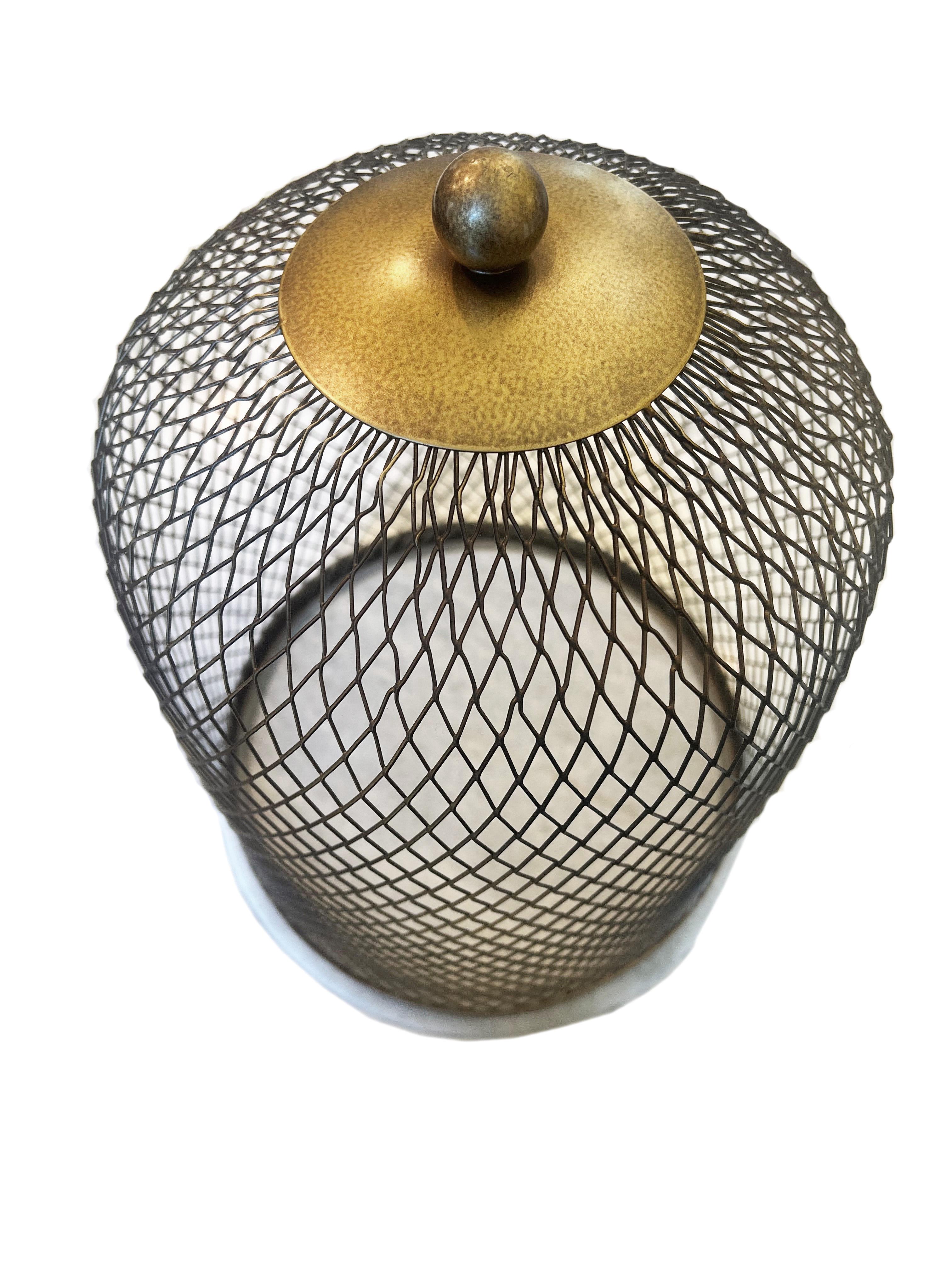 Elevate your home decor with this exquisite iron mesh cloche, presenting a harmonious blend of utility and elegance. The cloche features a sophisticated antique brass finish that exudes a warm, vintage charm, perfectly complemented by its luxurious