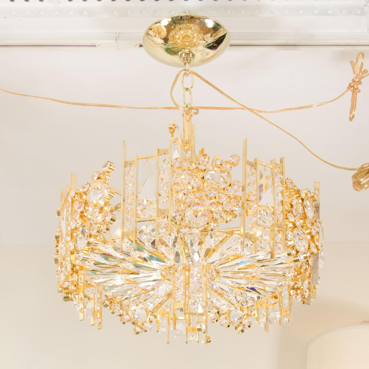 Brass chandelier composed of densely clustered inset crystal elements with decorative collar detail by Palwa.