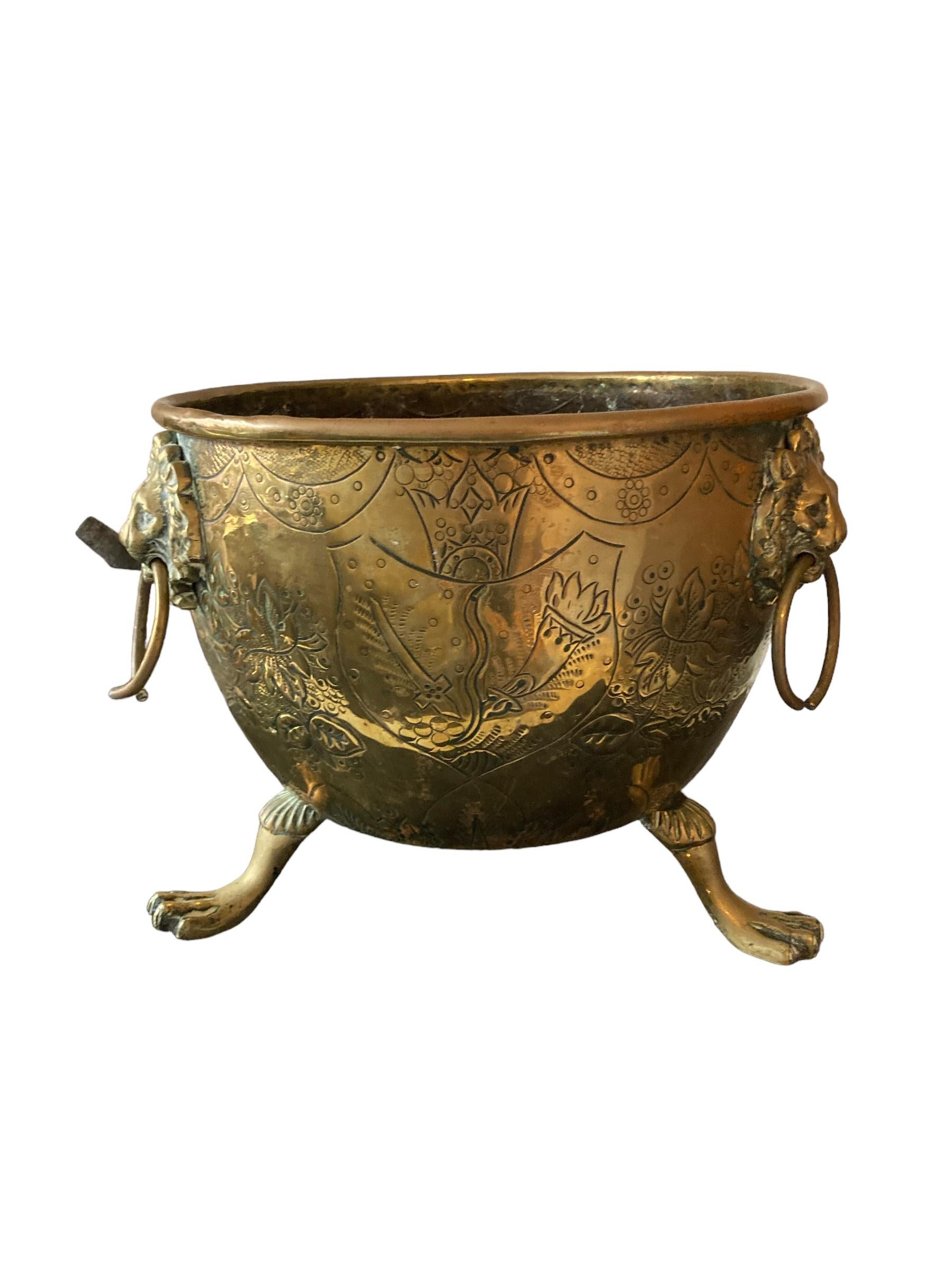 Brass coal scuttle, fire side bucket, Lion Paw Tri feet and Lion Head Handle. Ornate decorative engravings. Mid to late Late 19th Century dating around 1850.
H: 27 cm
W: 34 cm
D: 34 cm