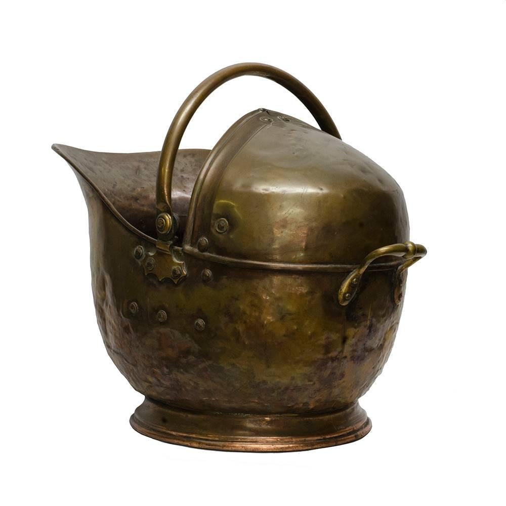 This 1880s era coal bucket is a beautiful antique accent for any fireplace. The decorative mountings, with both a rear and top handle, and traditional helmet style make for a graceful form with great functionality.