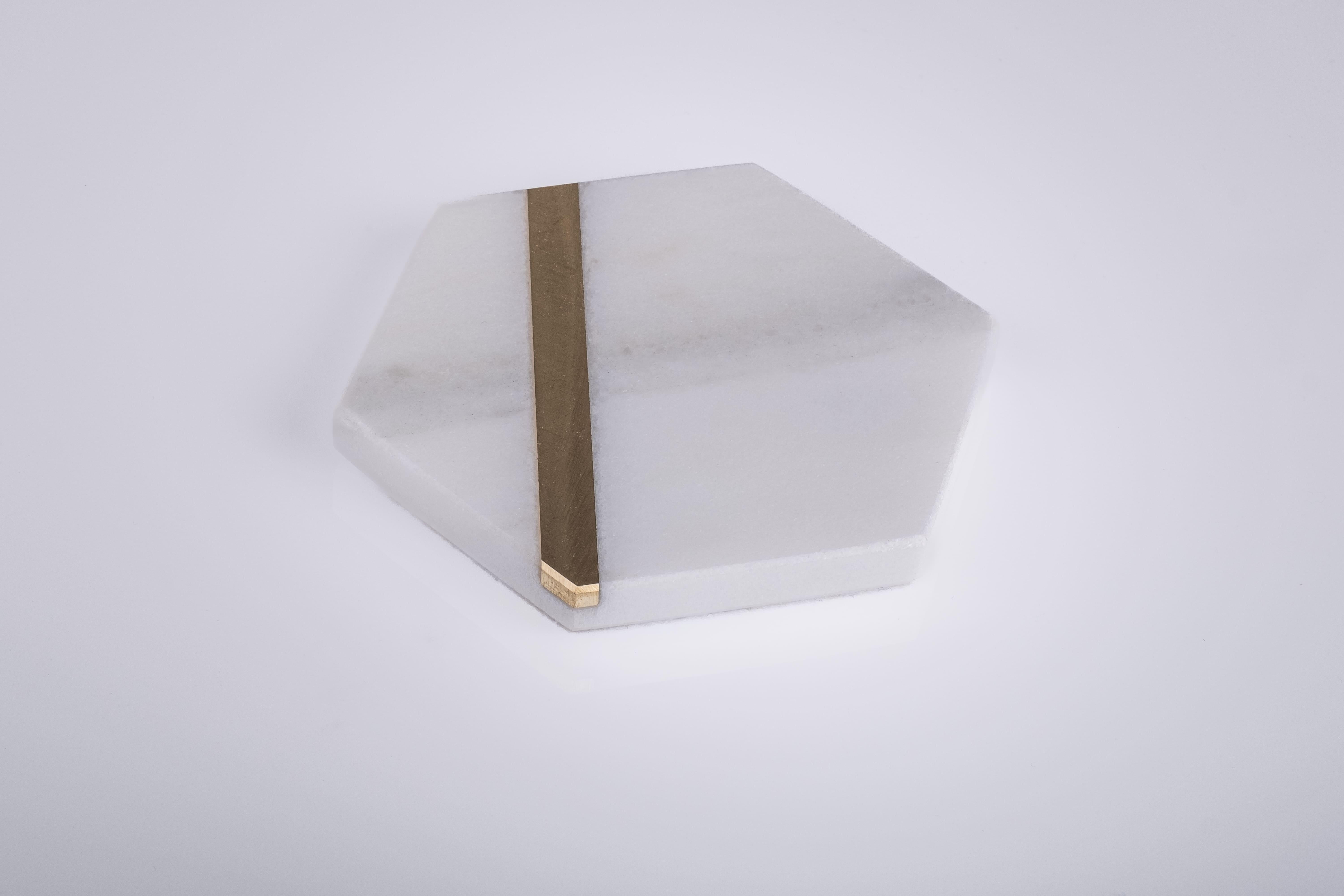 Les dessous de verre en laiton, entièrement réalisés en marbre Calacatta Oro, sont des dessous de verre exclusifs ornés d'une languette en laiton qui parcourt l'objet d'un bout à l'autre, lui conférant ainsi une touche supplémentaire de style