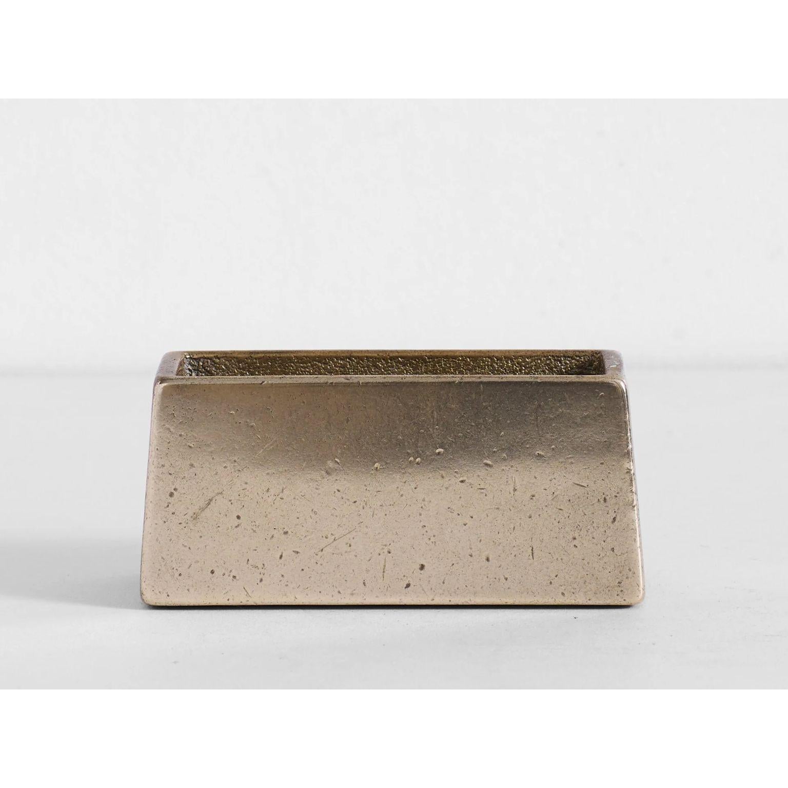 Brass Coaster Holder With Tan Coaster Set by Henry Wilson
Dimensions:  W 11 x D 4 x H 5 cm (Coaster Holder dimensions)
Materials: Solid brass, Leather

Sand cast in solid brass and hand finished.
Holds 6 Tan leather coasters that are included with