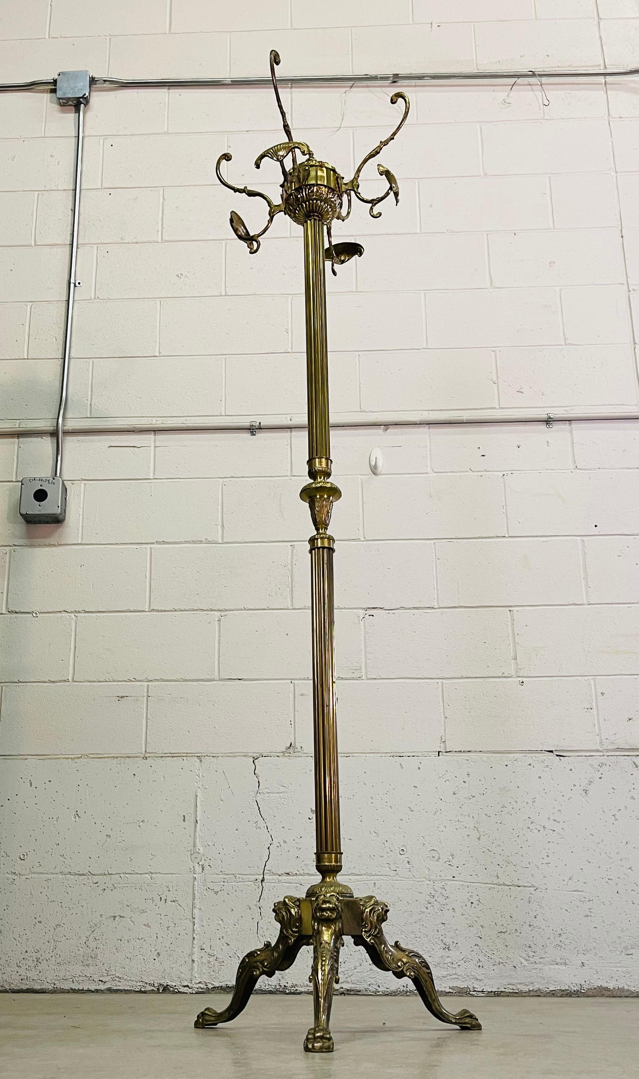 Vintage brass heavy and sturdy coat rack with lion head accents. The coat rack has double and single hooks with a fluted shaft. The base has the lion heads and paws. No marks.
