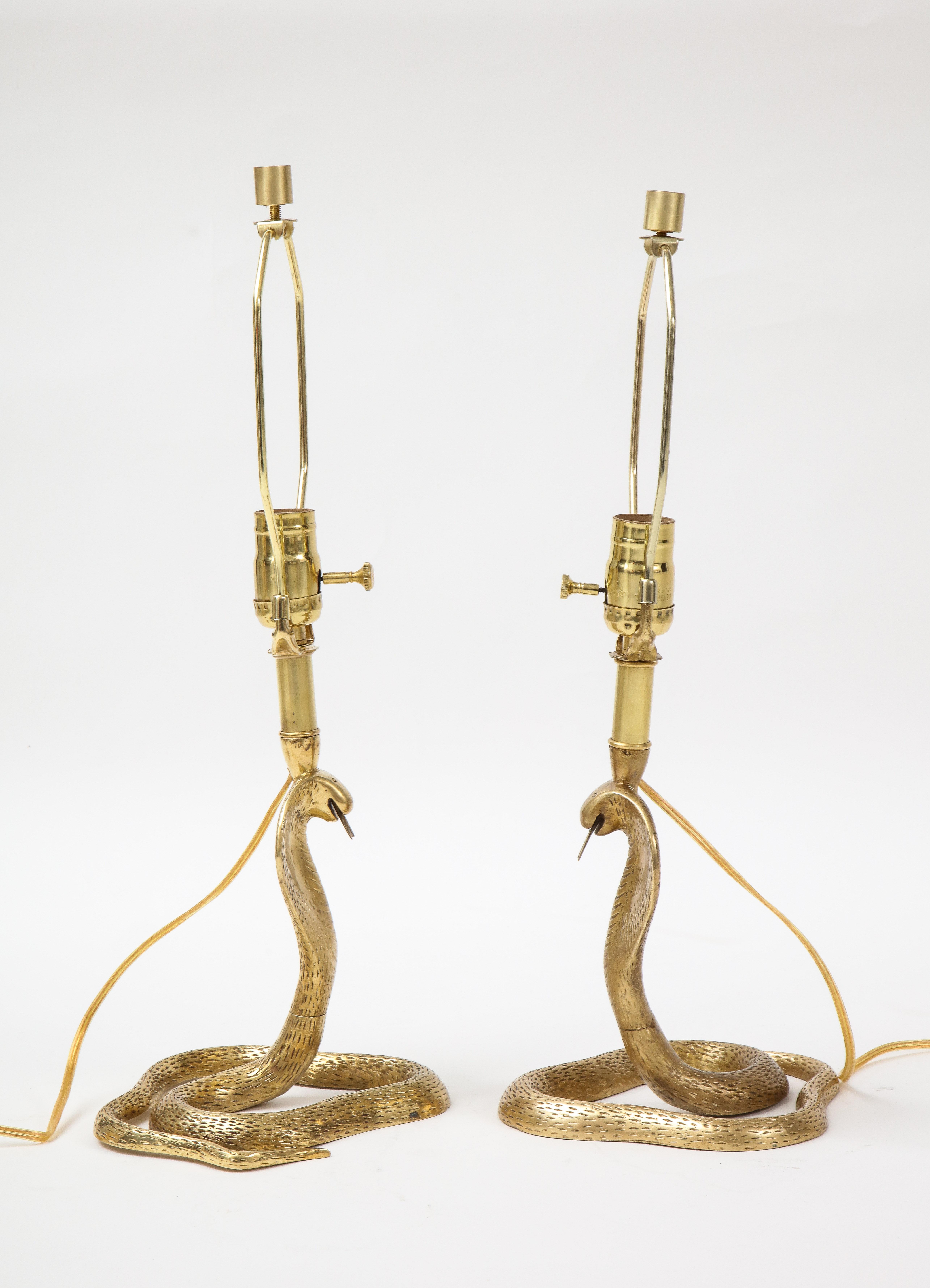 Detailed pair of hand finished cast brass cobra snake lamps in the Maison Jansen style. Rewired for use in the USA. 100W max bulb.