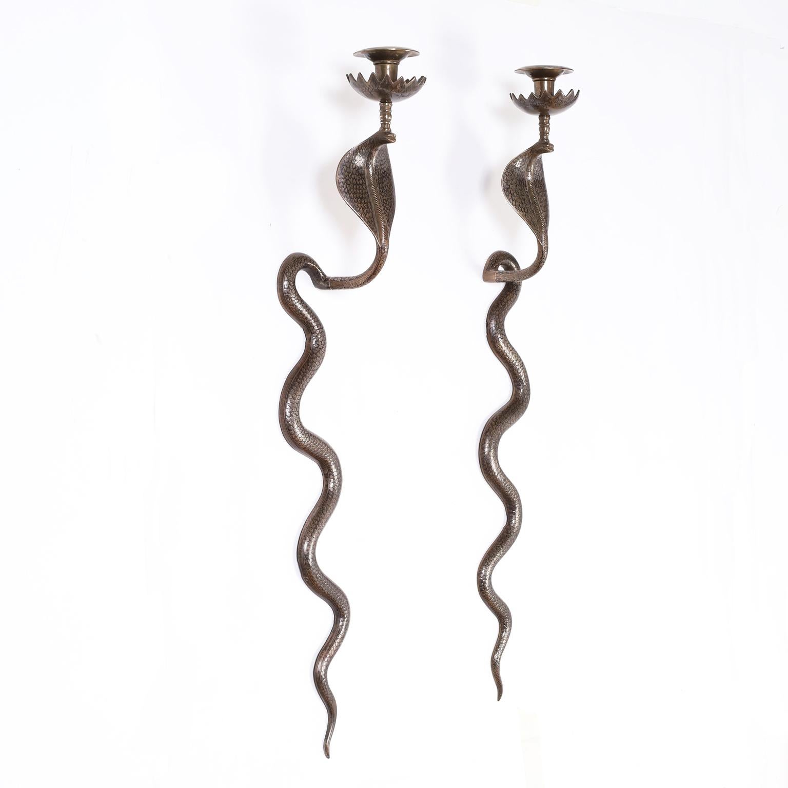 Pair of Anglo Indian mid century cast brass wall sconces in the form of cobras or snakes and highlighted with black enamel.