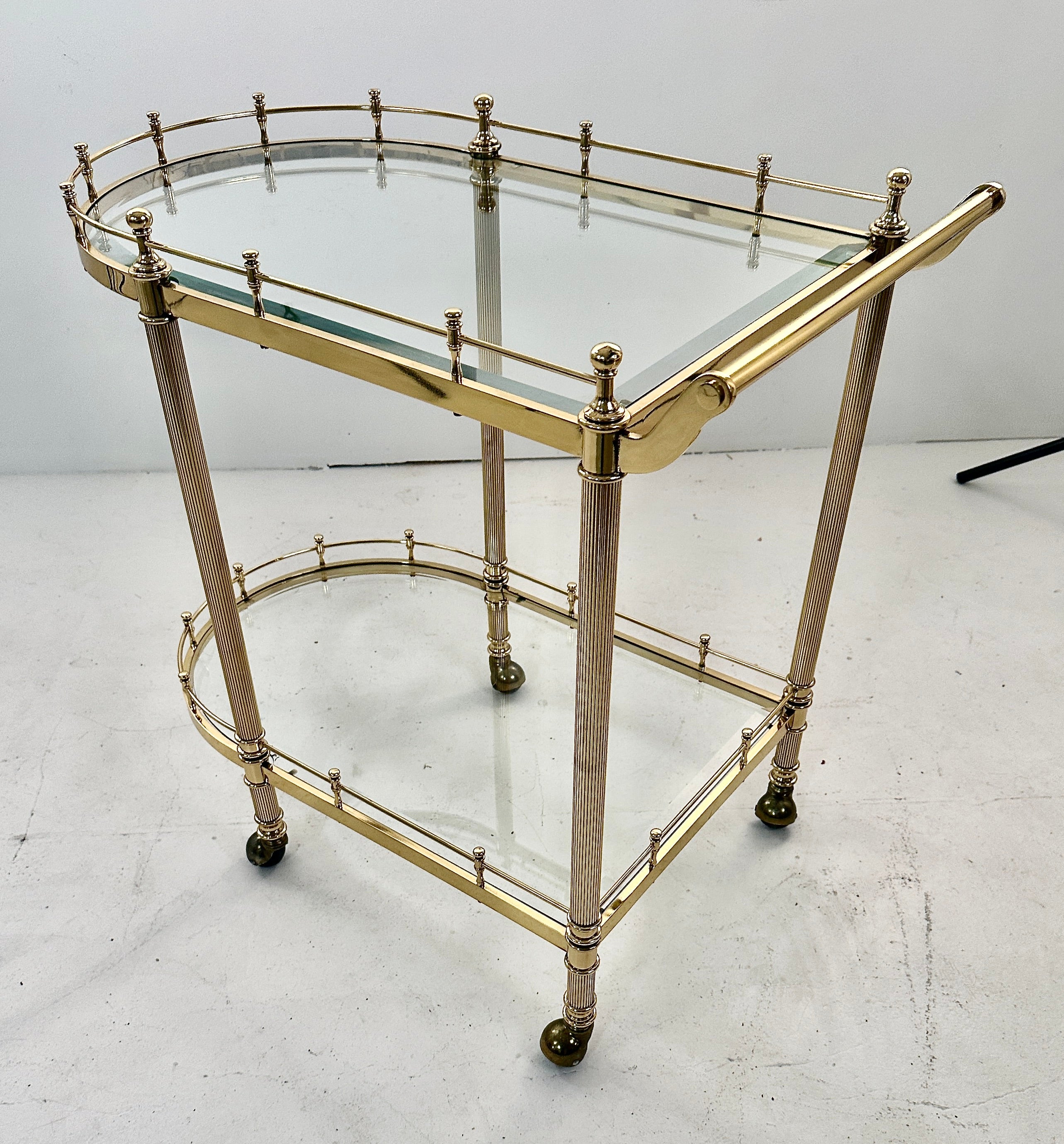 Calidad superior en este carro de cóctel de latón macizo. Con cristal biselado, galería elevada y patas estriadas. Este artículo se ha pulido y lacado recientemente. 