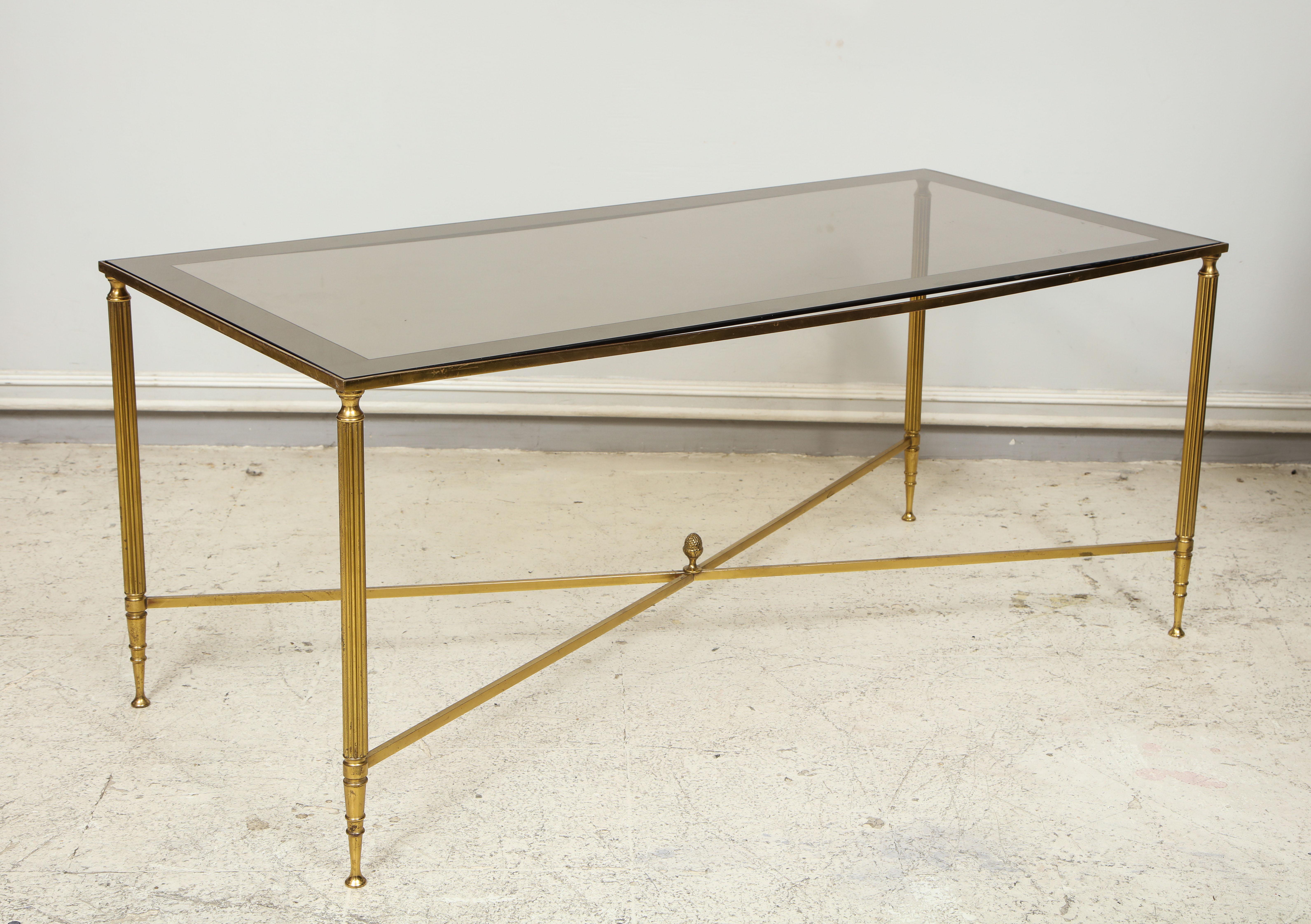 Brass cocktail table with smoked-glass top on stretchers base.