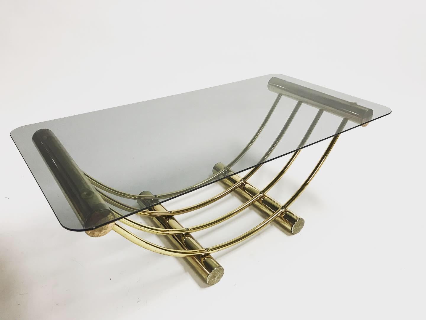 Brass 'arch' coffee table in the style of Romeo Rega.

The table has a rounded smoked glass top, typical for the seventies.

The table was made in Belgium by Belgochrom.

1970s, Belgium

Slight patina on the brass

Dimensions:
Height
