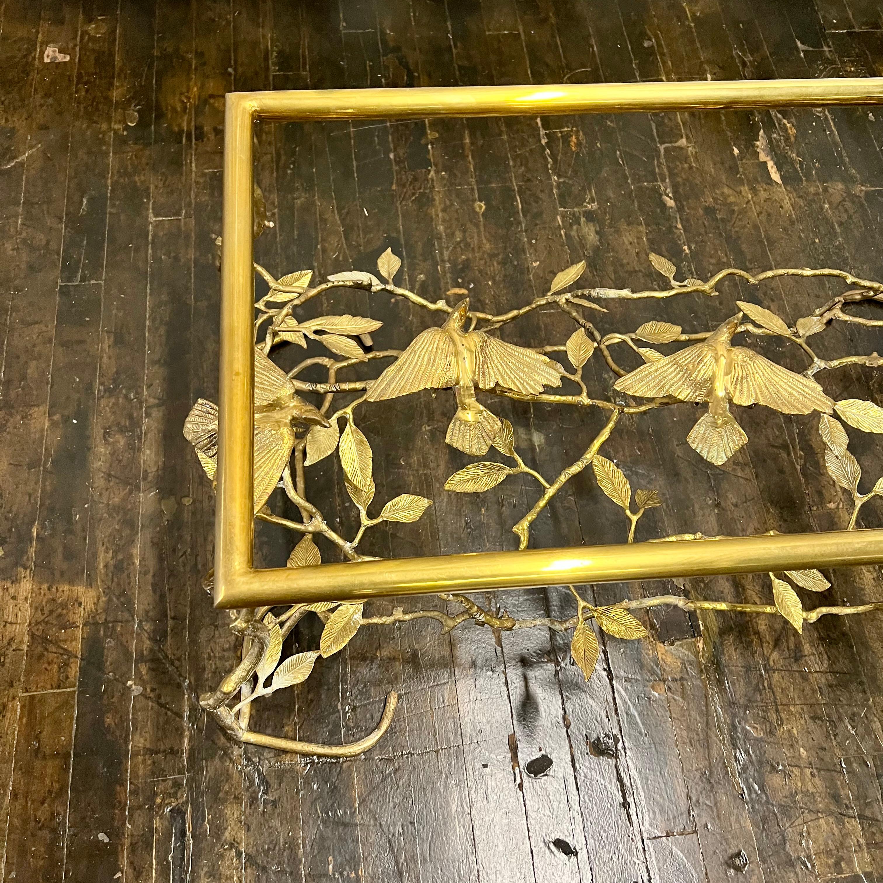 Beautiful organic tree form brass cocktail or coffee table with birds, nice overall bronzed patina finish. Intricately constructed with branches that are filled with scattered leaves and perched birds. The table base is suited for a rectangular