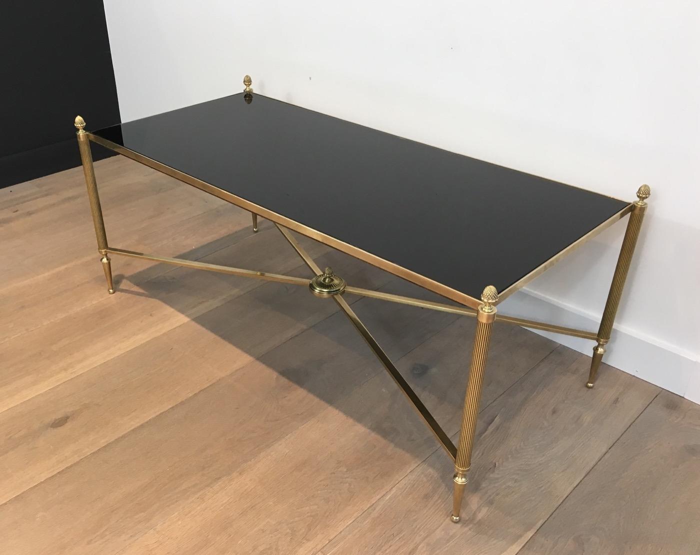 Cette table basse de style néoclassique est fabriquée en laiton avec un plateau en verre laqué noir. Il s'agit d'une œuvre française de la Maison Baguès. Circa 1940