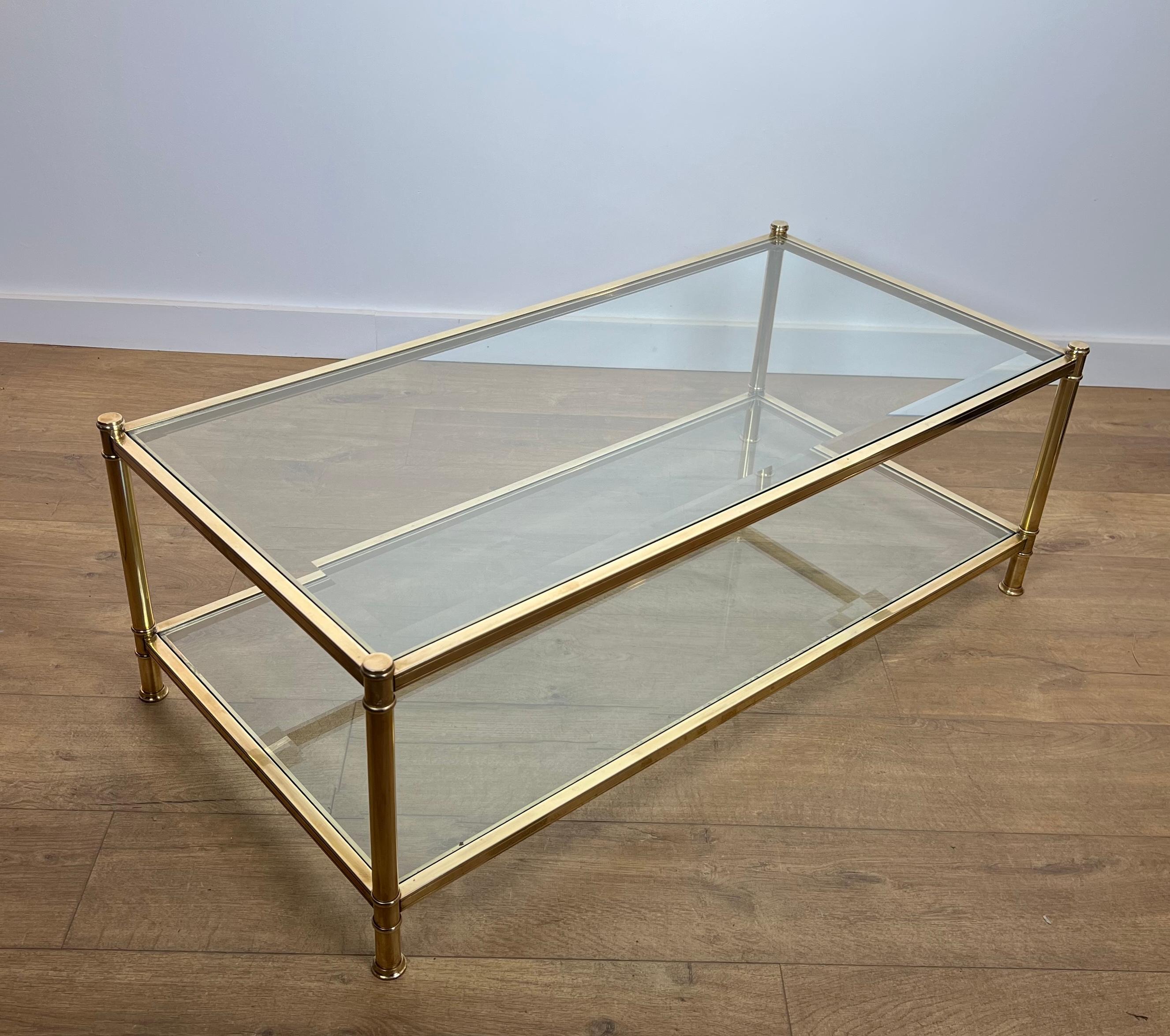 Cette très belle et élégante table basse est en laiton avec 2 étagères en verre. Le verre supérieur est biseauté sur tout le pourtour. Il s'agit d'un ouvrage français de Roche Bobois. Circa 1970