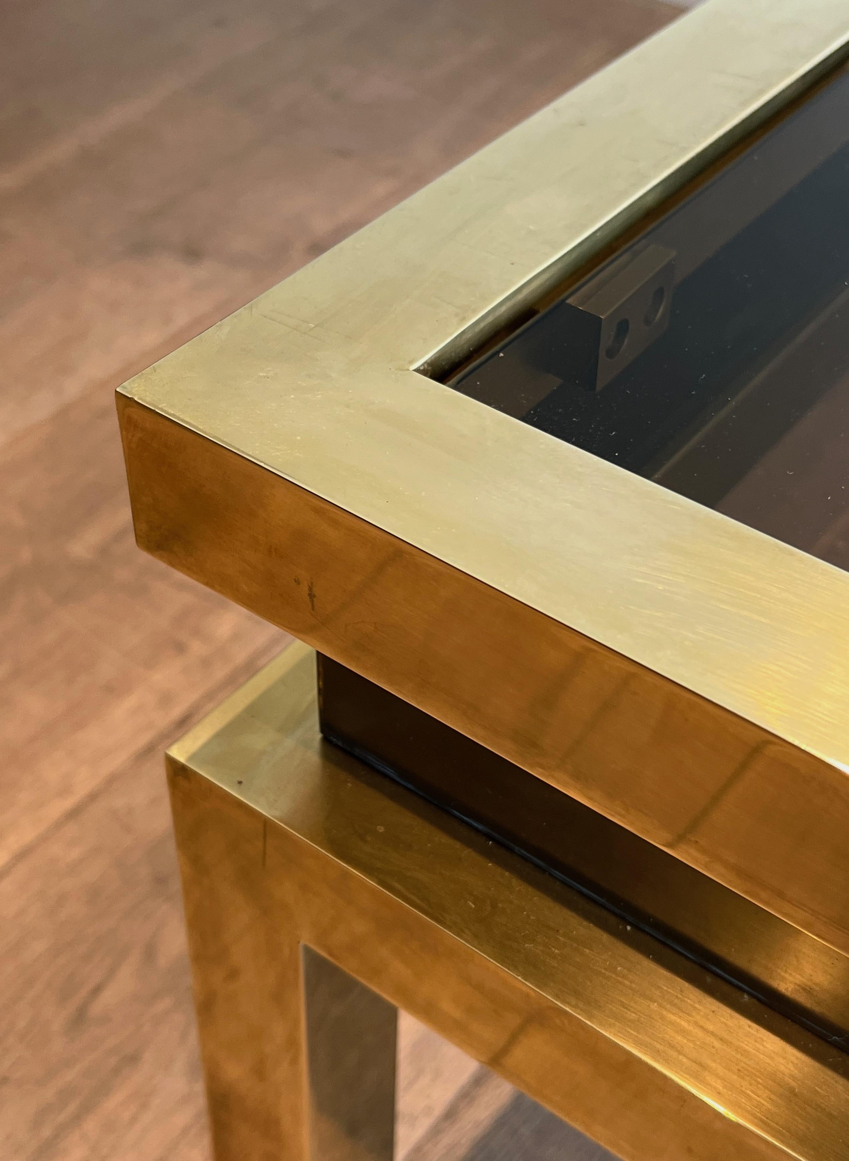 Laiton Table basse en laiton avec laque noire et plateau en verre fumé par Guy Lefèvre en vente