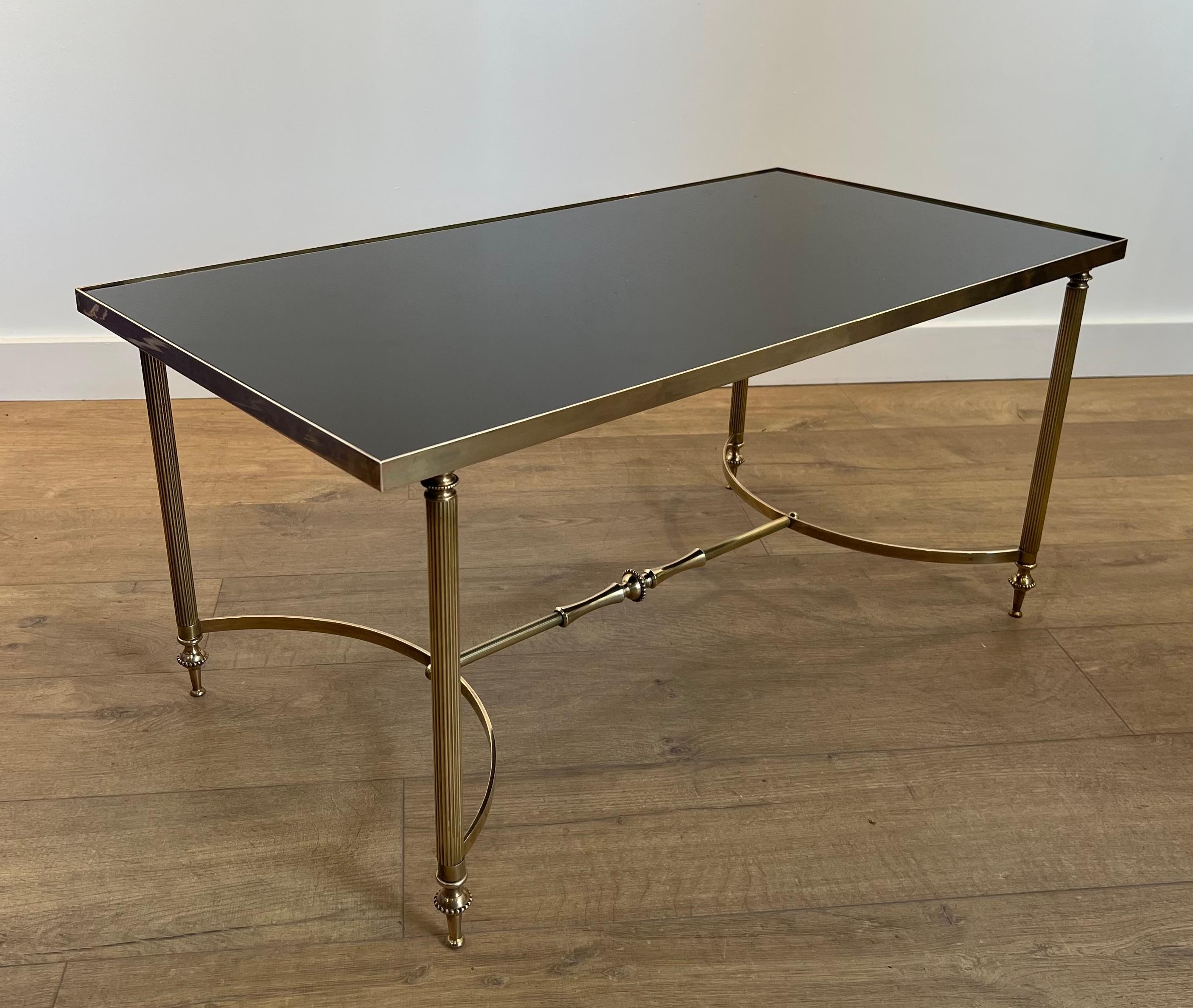 Cette très belle table basse rectangulaire est en laiton avec un plateau en verre laqué noir. Il s'agit d'un  Œuvre française de la Maison Jansen Circa 1940