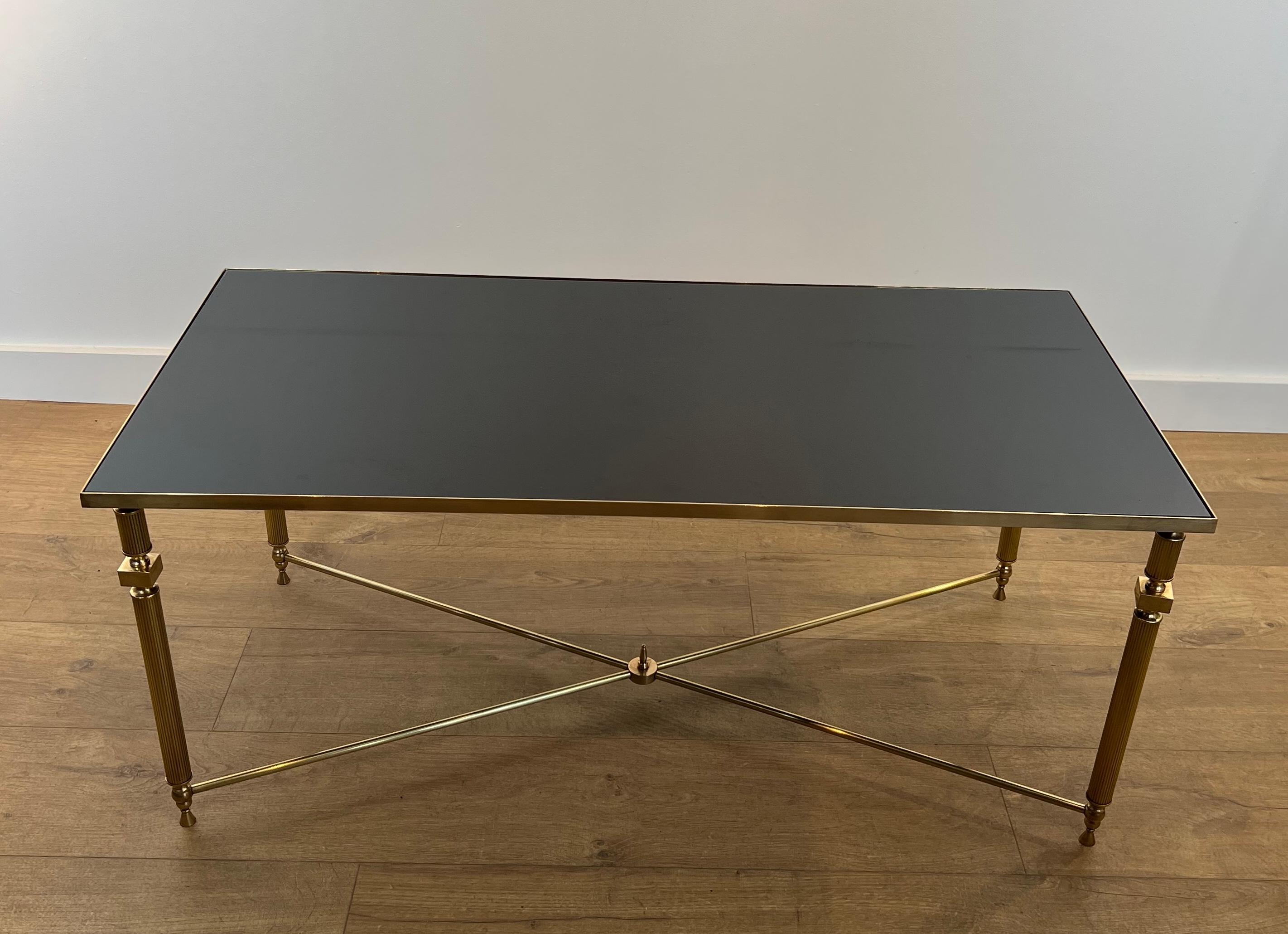 This rectangular coffee table is made of brass with black lacquered glass top. This is a French work in the style of Maison Jansen. Circa 1940