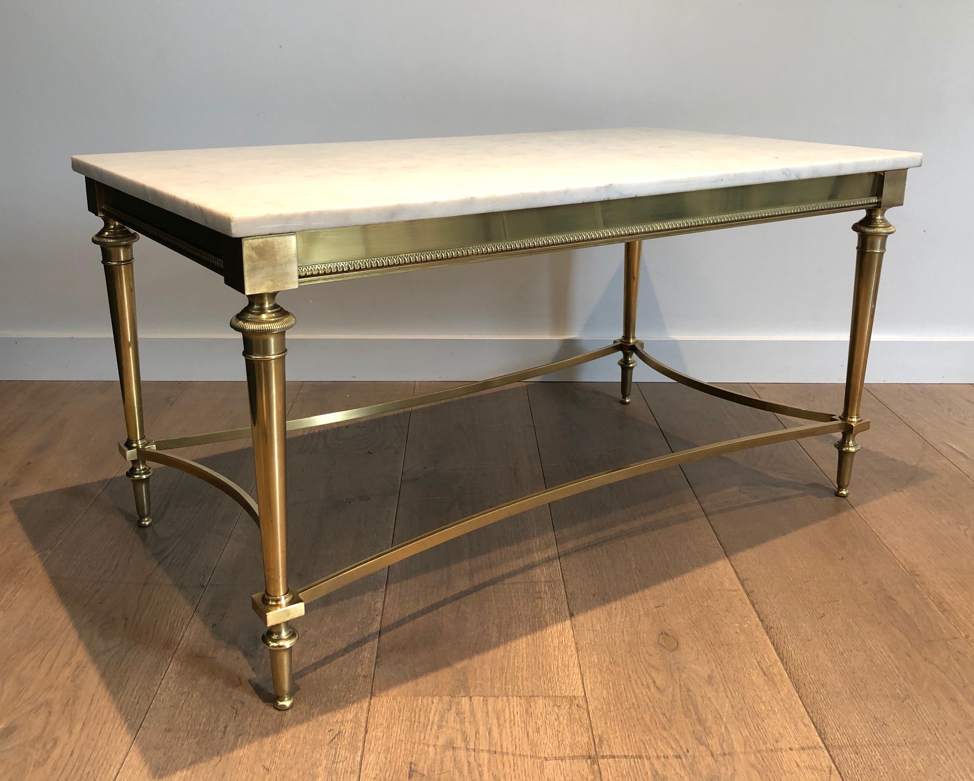 This exceptional neoclassical style coffee table is made of brass with white Carrara marble top. This is a French work by famous designer Maison Ramsay. Circa 1940