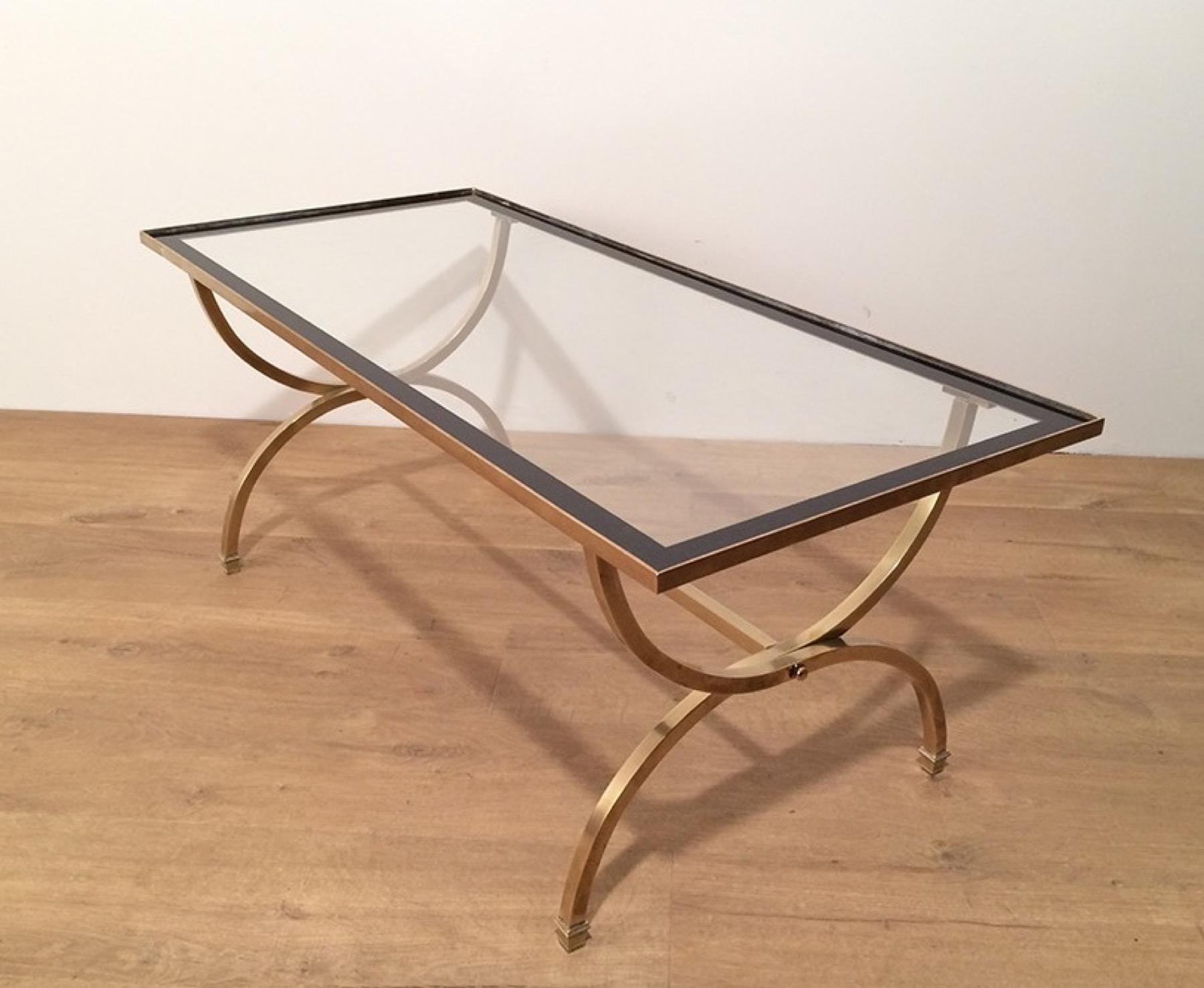 Cette très belle table basse rectangulaire est fabriquée en laiton avec un plateau en verre transparent entouré de bords laqués noirs. Il s'agit d'un ouvrage français de la Maison Jansen. Circa 1940