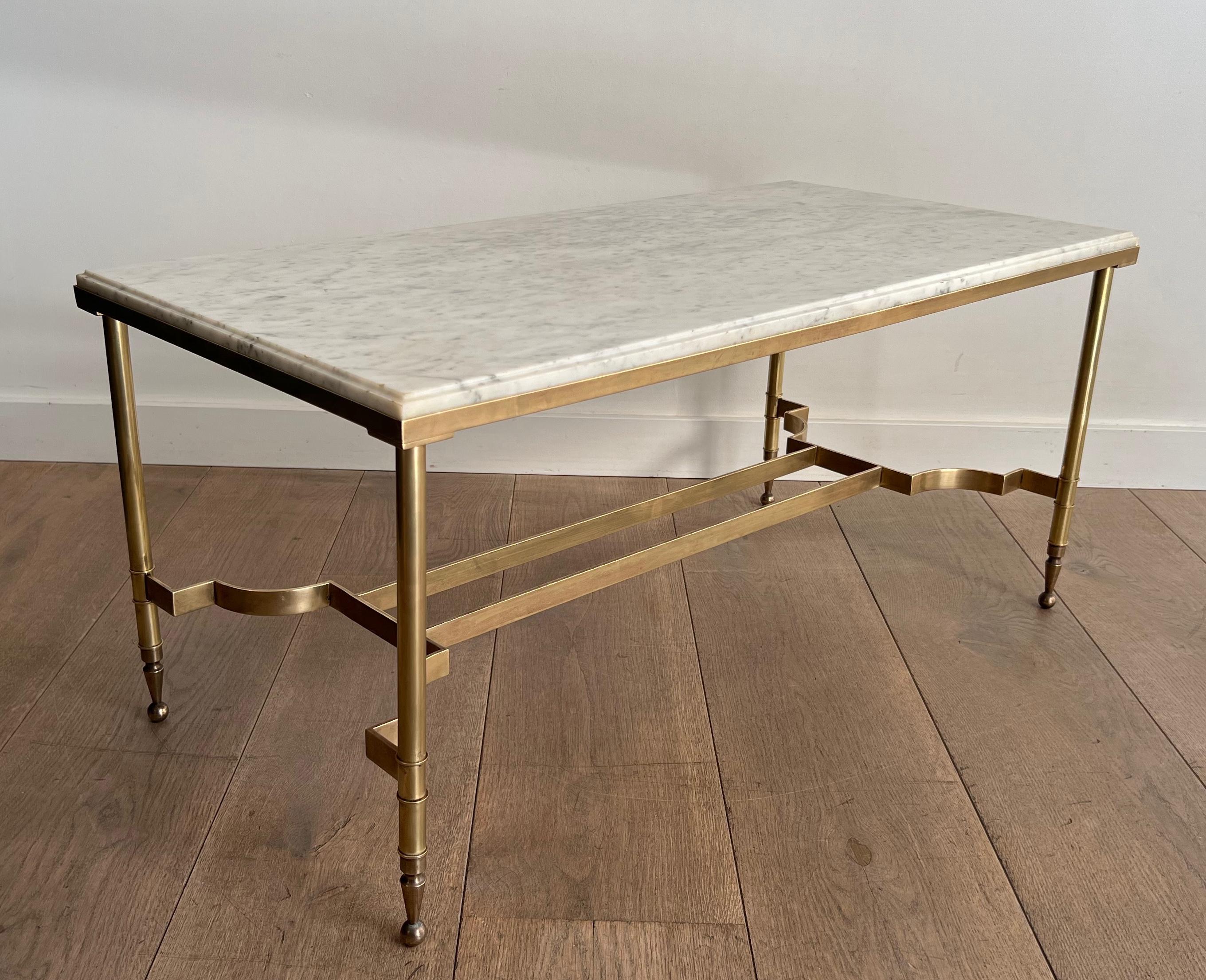 Cette très belle et élégante table basse de style néoclassique est en laiton avec un plateau en marbre blanc. Il s'agit d'un ouvrage français de la Maison Jansen. Circa 1940