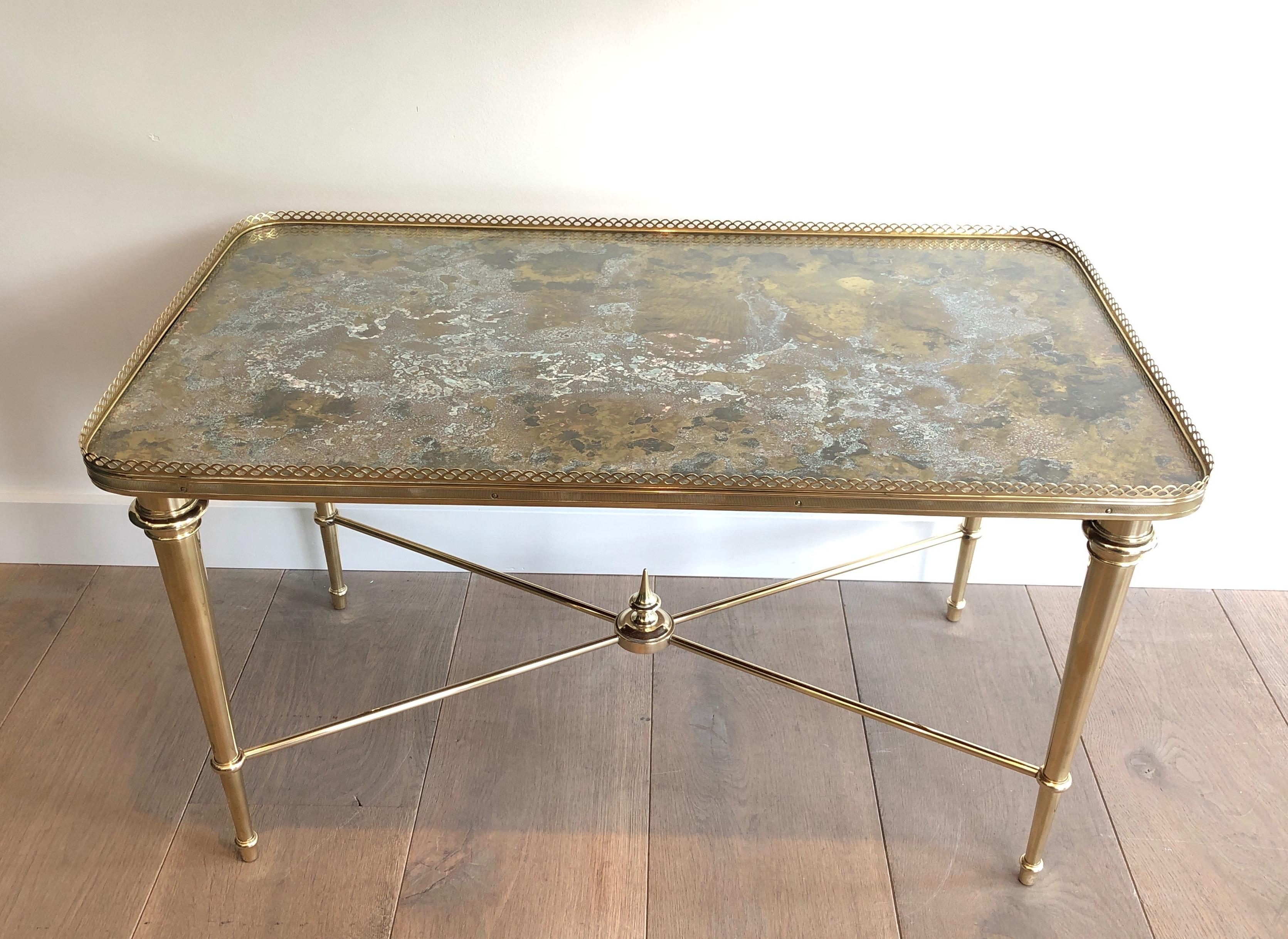 This coffee table is made of brass with an oxidized and patinated brass top with glass on top. This is a French work by famous Maison Ramsay. The table is marked underneath. Circa 1940.