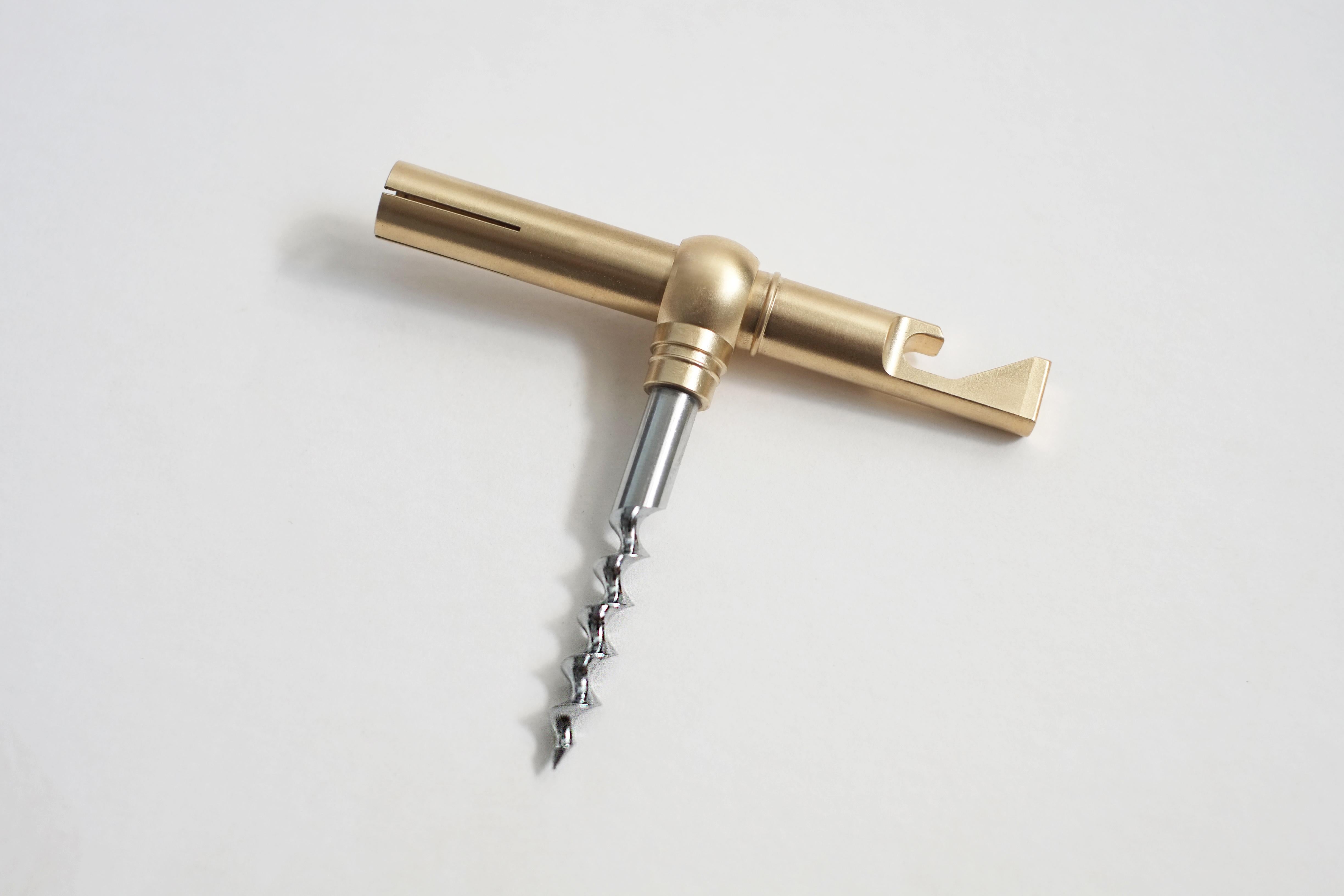 This multifunctional brass bar tool is one you are not going to want to keep hidden in a drawer. 

Machined from a solid bar of brass, the slender body holds a steel corkscrew spiral inside of a split sheath reminiscent of a collet. Open and close