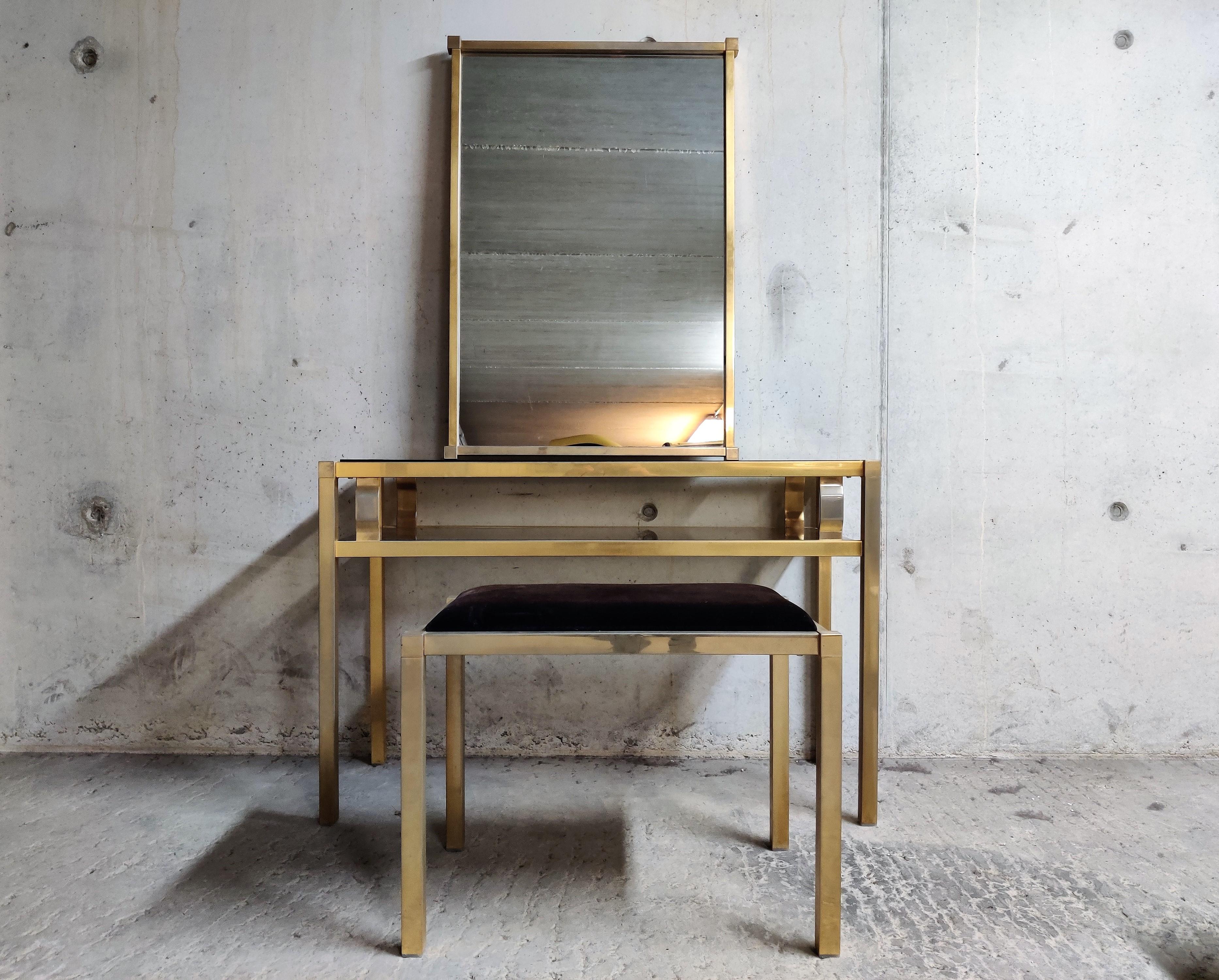 Vintage brass console table with matching mirror and stool.

The console table has crystal smoked glass tops.

The console table is in original untouched condition as is the mirror and the stool.

Beautiful set, ideal for a hallway or