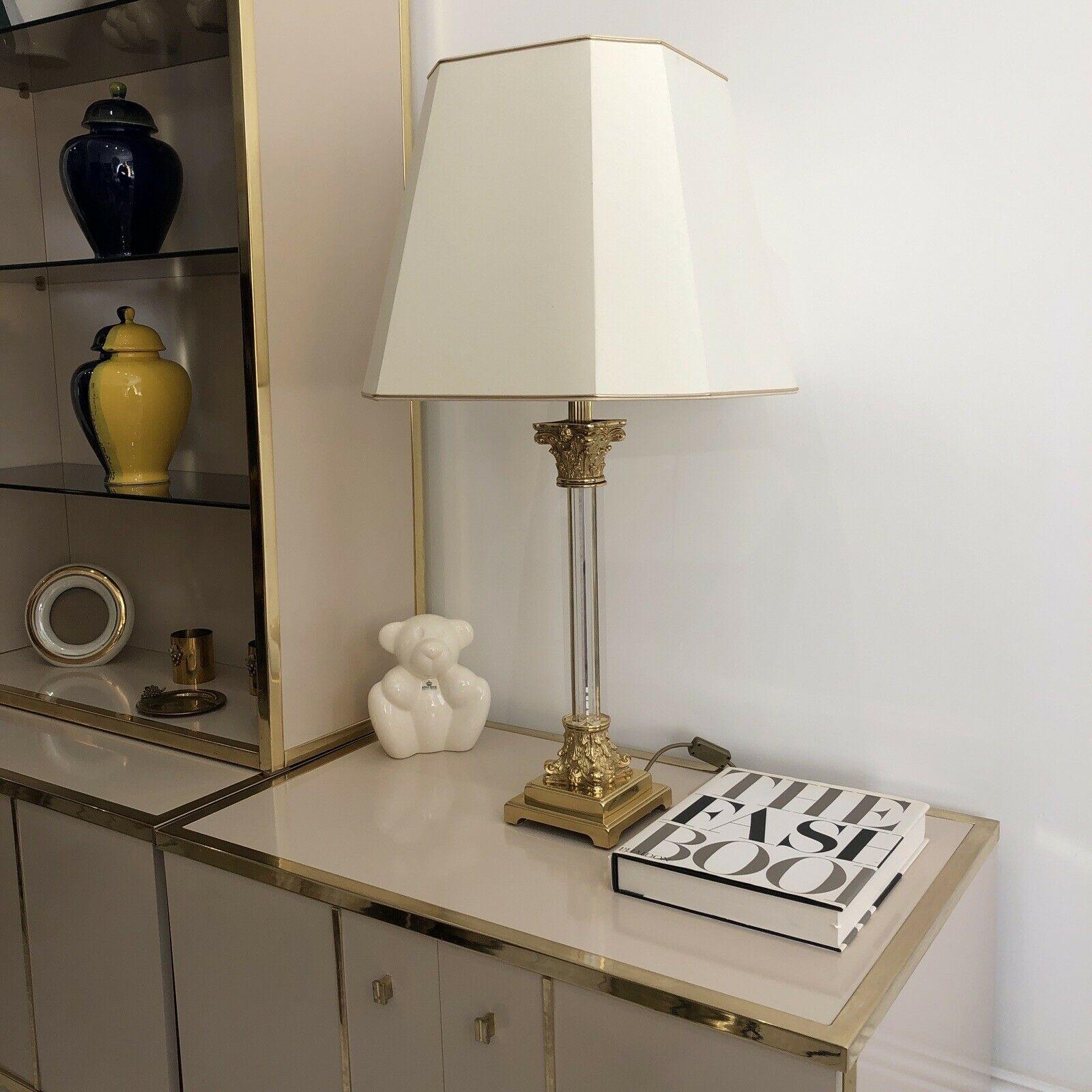 An impressive in size but also design table lamp combined with brass gold plated intricate corinthian base and top with several pieces of lucite forming the body.

It comes with the original lamp octagonal lampshade.

It would look amazing in a