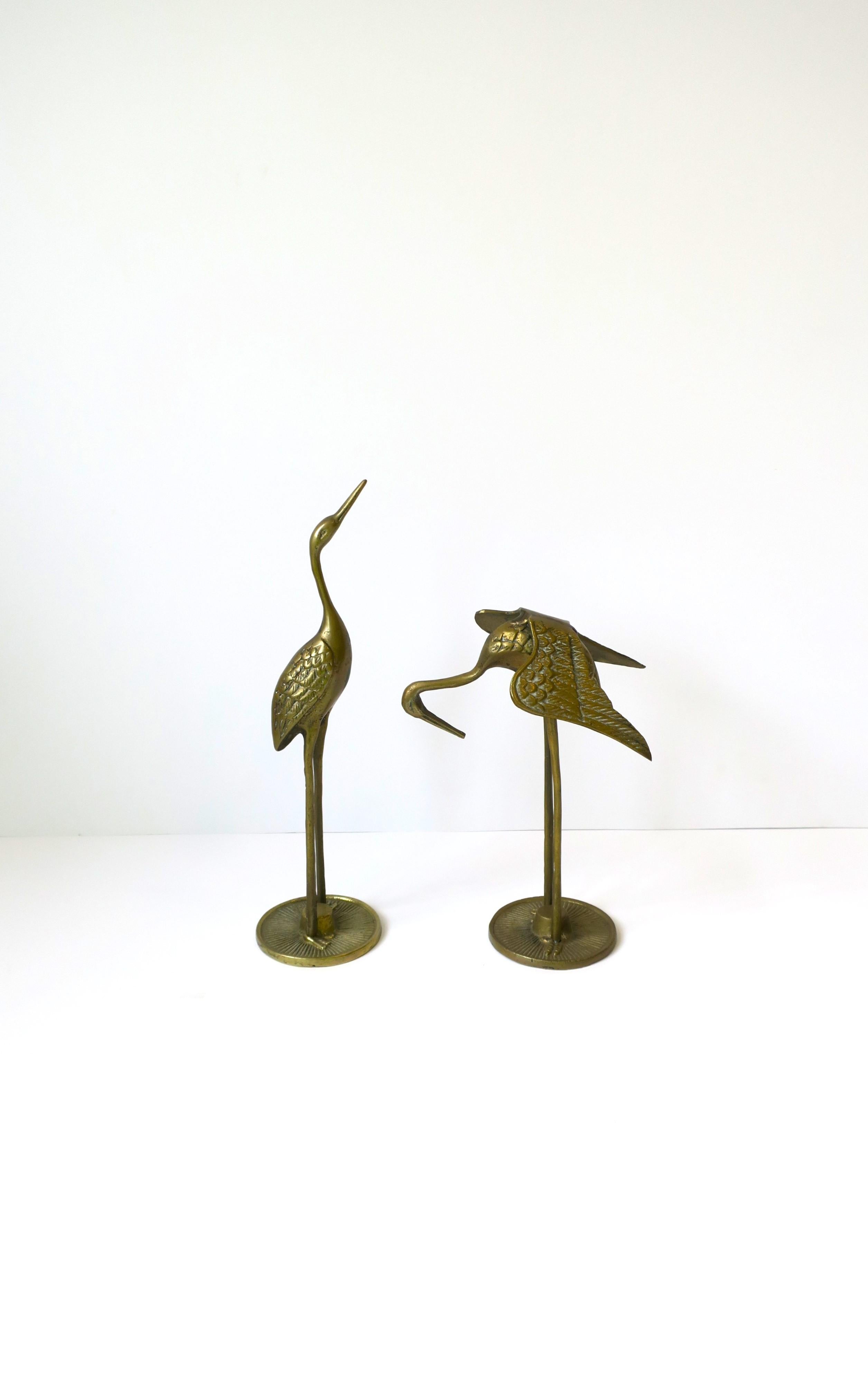 A pair/set of brass crane bird sculptures decorative objects, circa 1970s. Great pieces for a cocktail table, bookshelf, credenza, etc. 

Measurements, first and second image, L to R: 
3