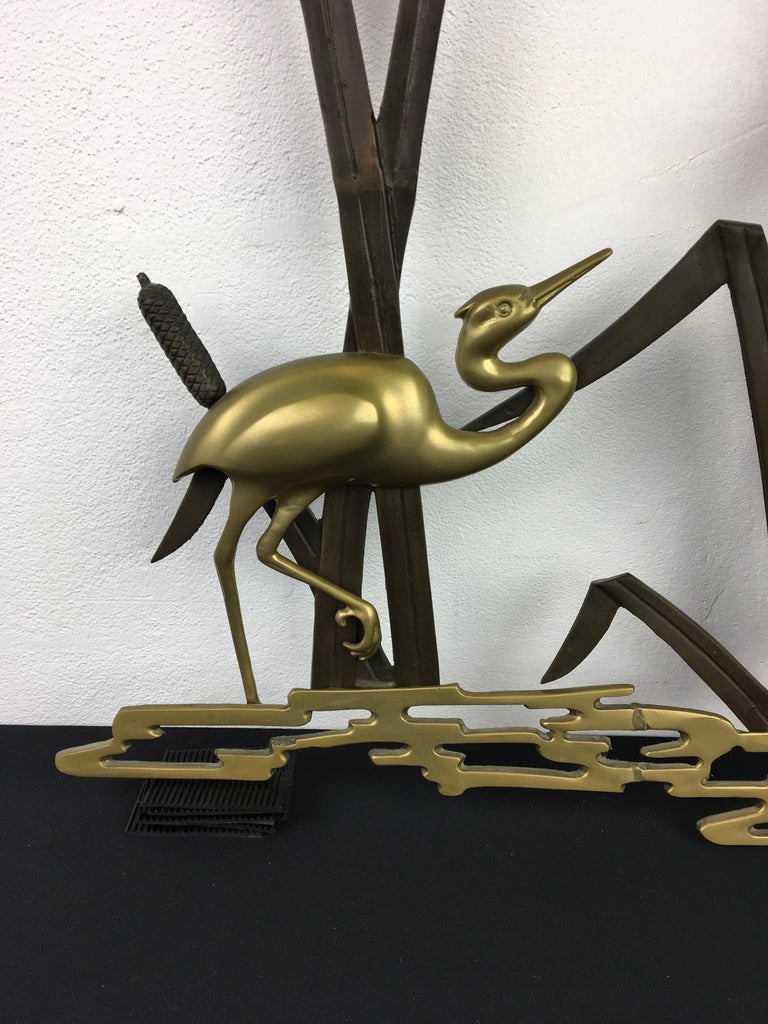 1960s wall sculpture with cranes. 
A  wall decoration piece with 2 crane birds made of brass or messing with bronzed metal. A landscape in nature with 2 cranes and cattail plants at the back. 
Stylish wall decoration - wall decor - wall