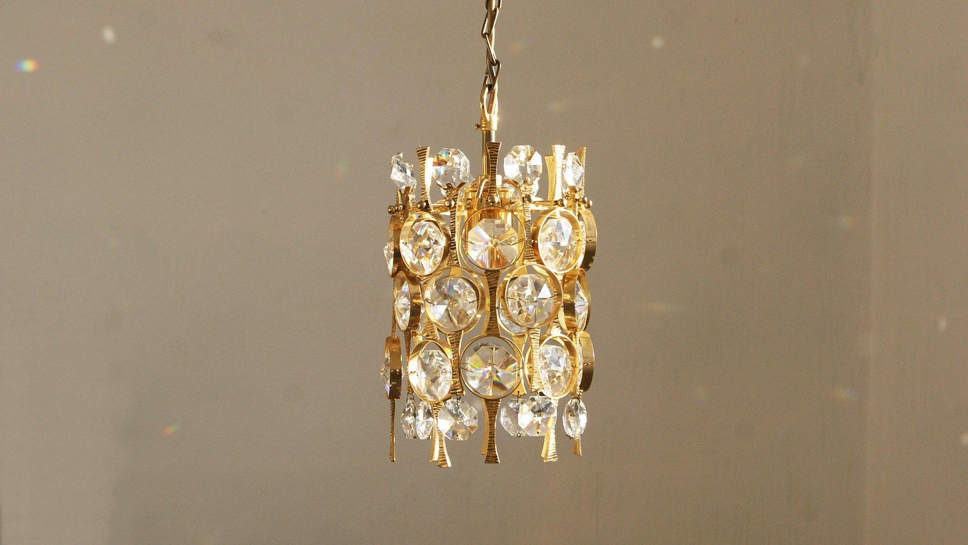 Lampada a sospensione in cristallo di Palwa.
Si tratta di una proposta di illuminazione decorativa per interni sofisticati in stile Hollywood Regency.
L'eleganza della lampada è garantita dalla finitura in ottone e dalla massima qualità degli