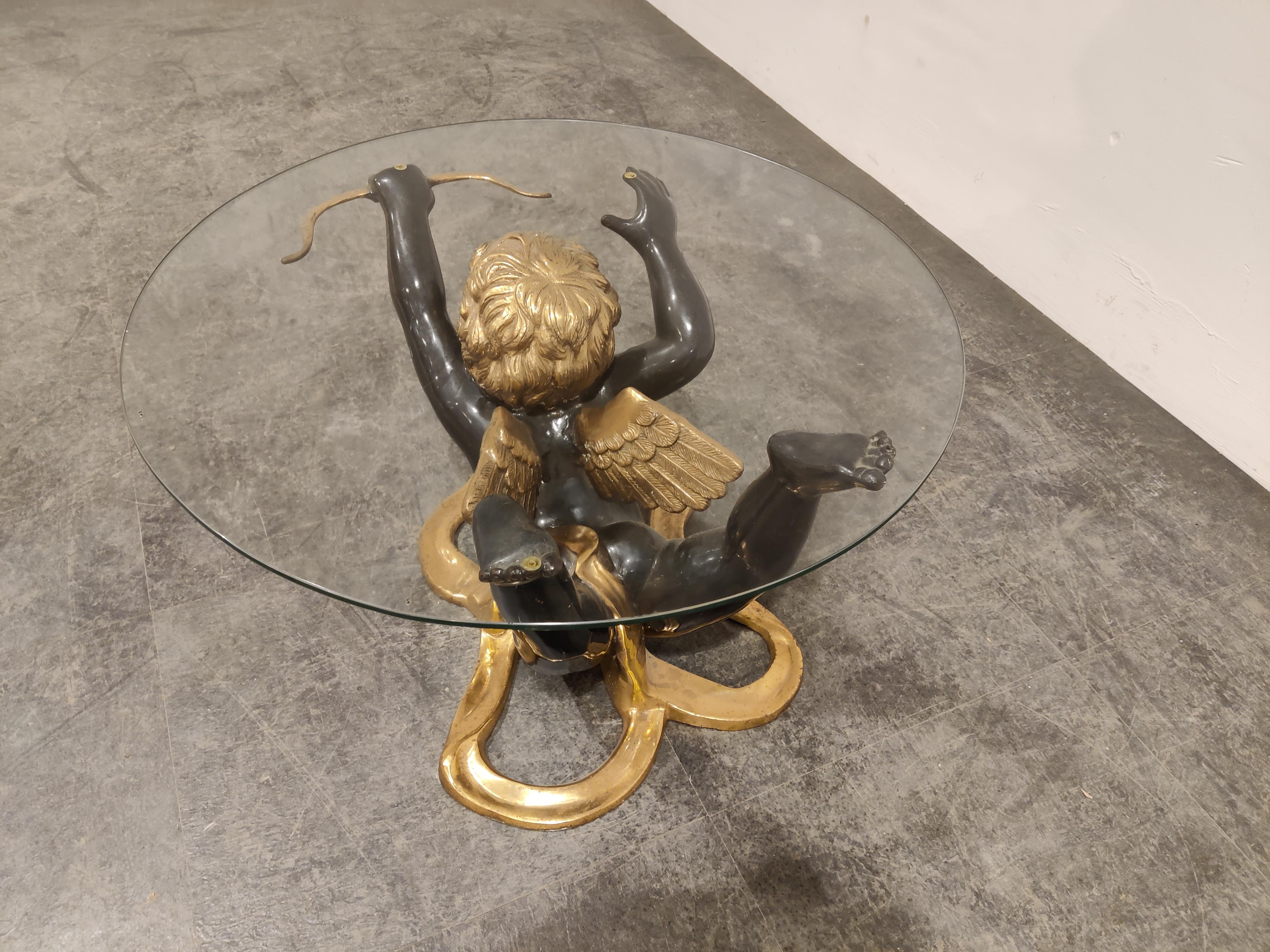 Brass coffee table with a cupid sculpture base.

This beautifully crafted and elegant coffee table comes with a round glass top.

Heavy quality.

1970s - Belgium

Dimensions:
Table:
Diameter: 70cm/27.55