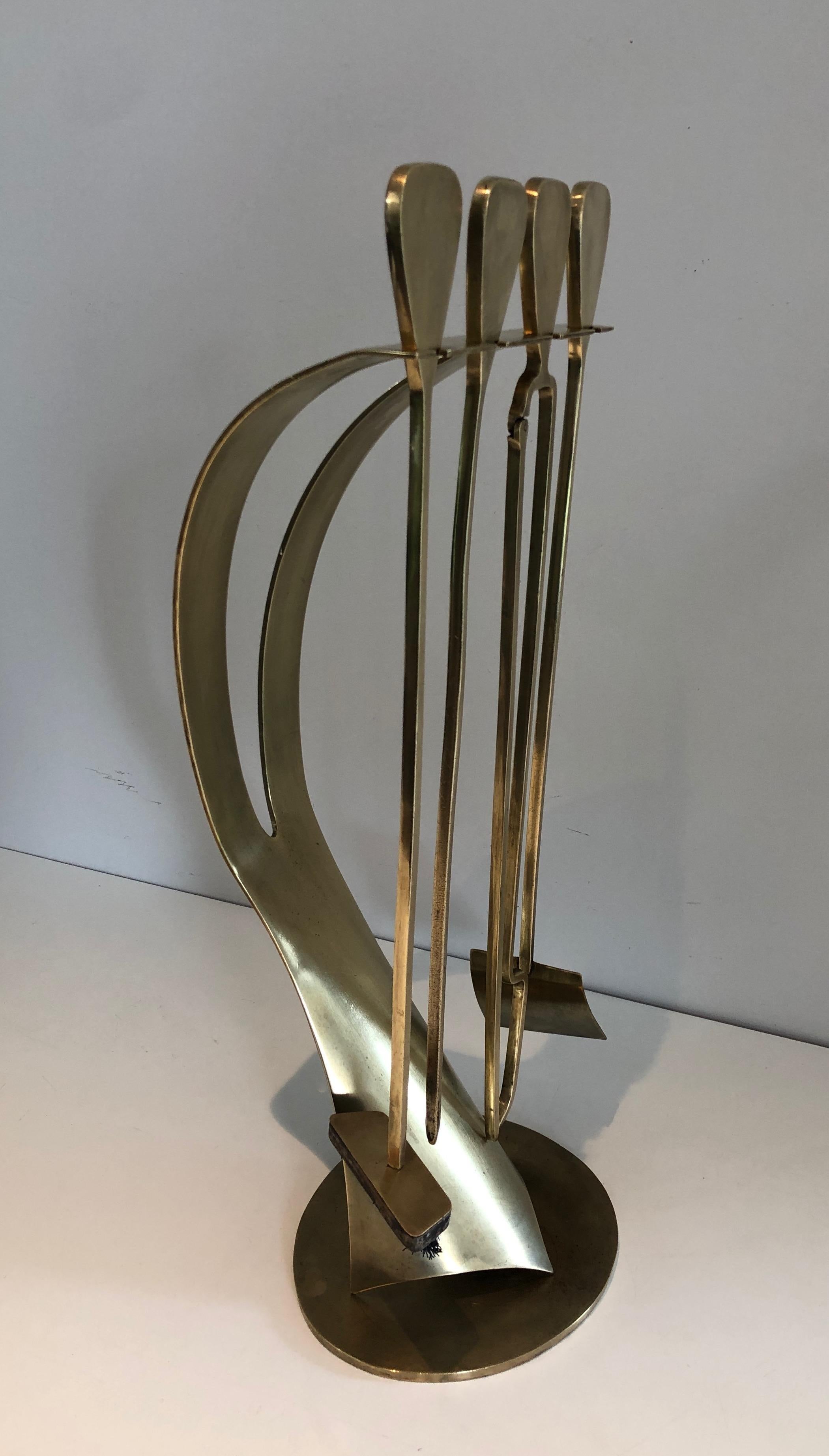 These design fireplace tools on stand are all made of brass. This is a French work, circa 1970.