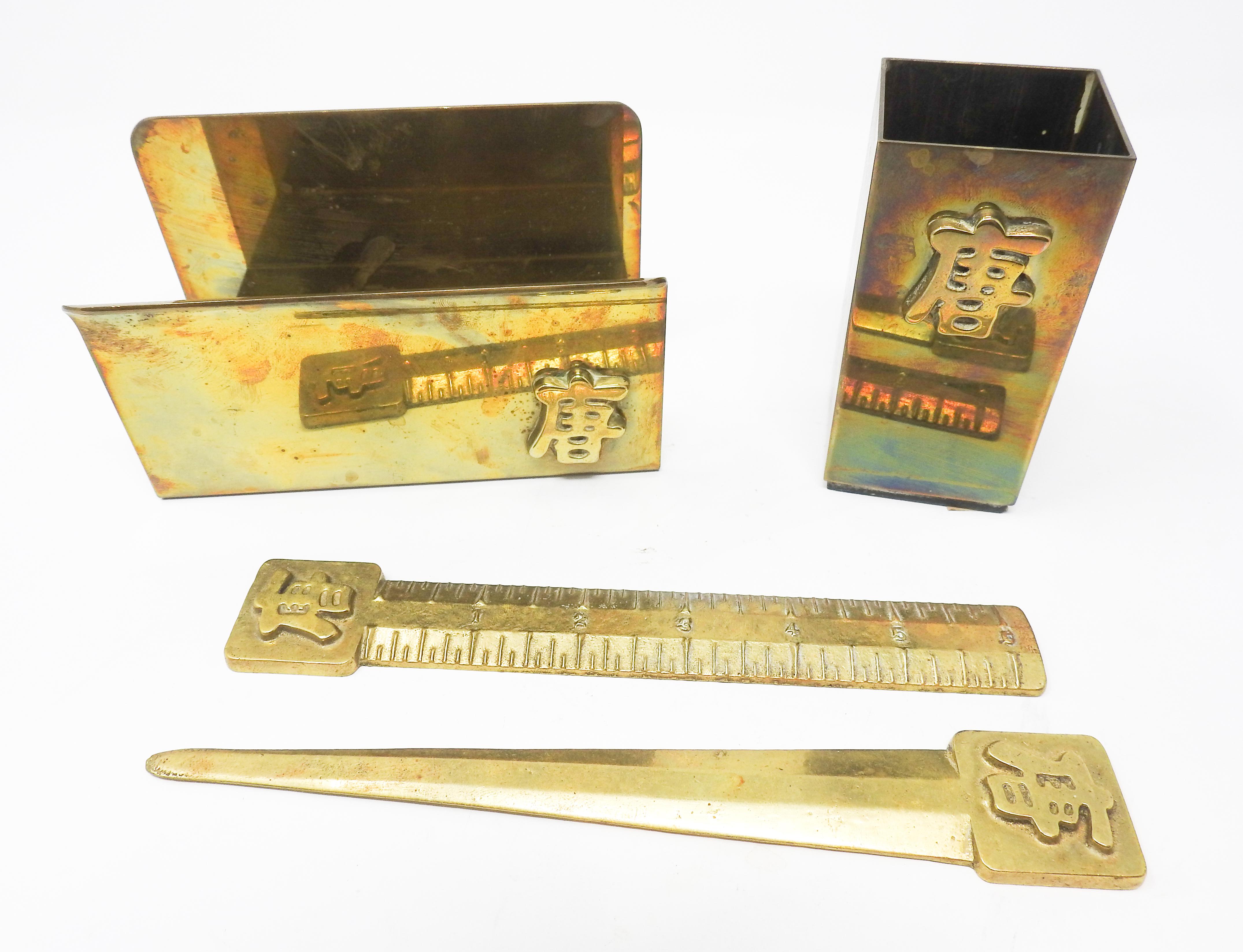 Offering this beautiful and simple brass desk set with Chinese symbol. There are four pieces that complete the set which are a mail or file holder, pen holder, a letter opener, and a ruler. Each piece has the same symbol on them and the ruler is