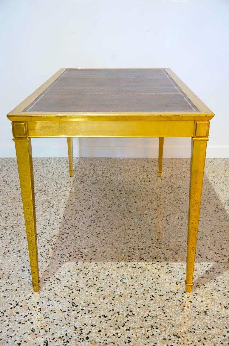 This stylish and chic solid brass desk is attributed to Maison Jansen and was acquired from a Palm Beach estate.

The leather top is a mottled brown with a gold edged border and the single drawer is lined with a deep brown velour type fabric.