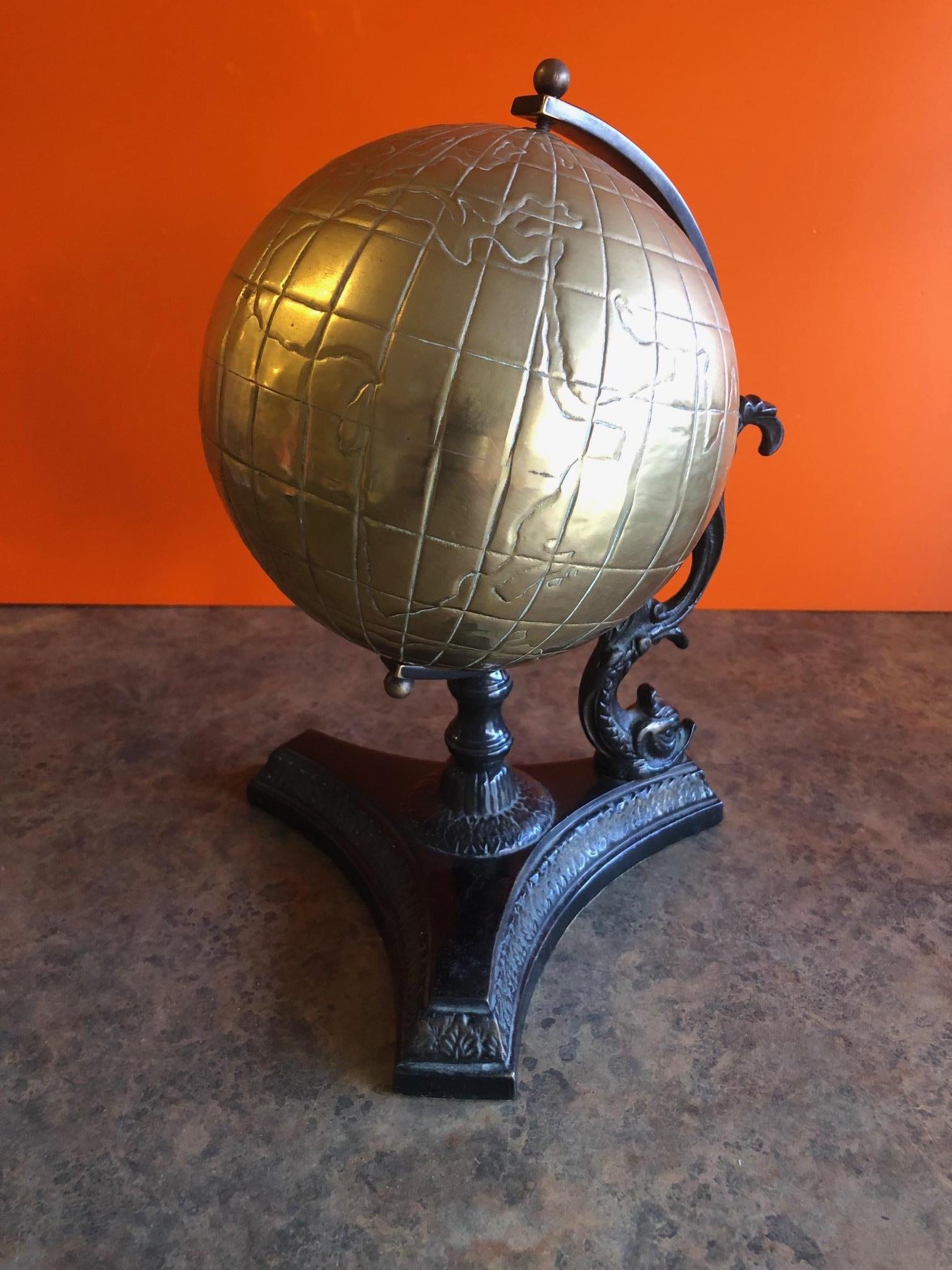 Unique old world brass desk globe, circa 2000s. Made of solid brass for long lasting visual appeal, this eye-catching golden globe is set atop of a dark platform with a dragon support.

Dimensions: 11 inches high x 9 inches wide x 8 inches deep.
