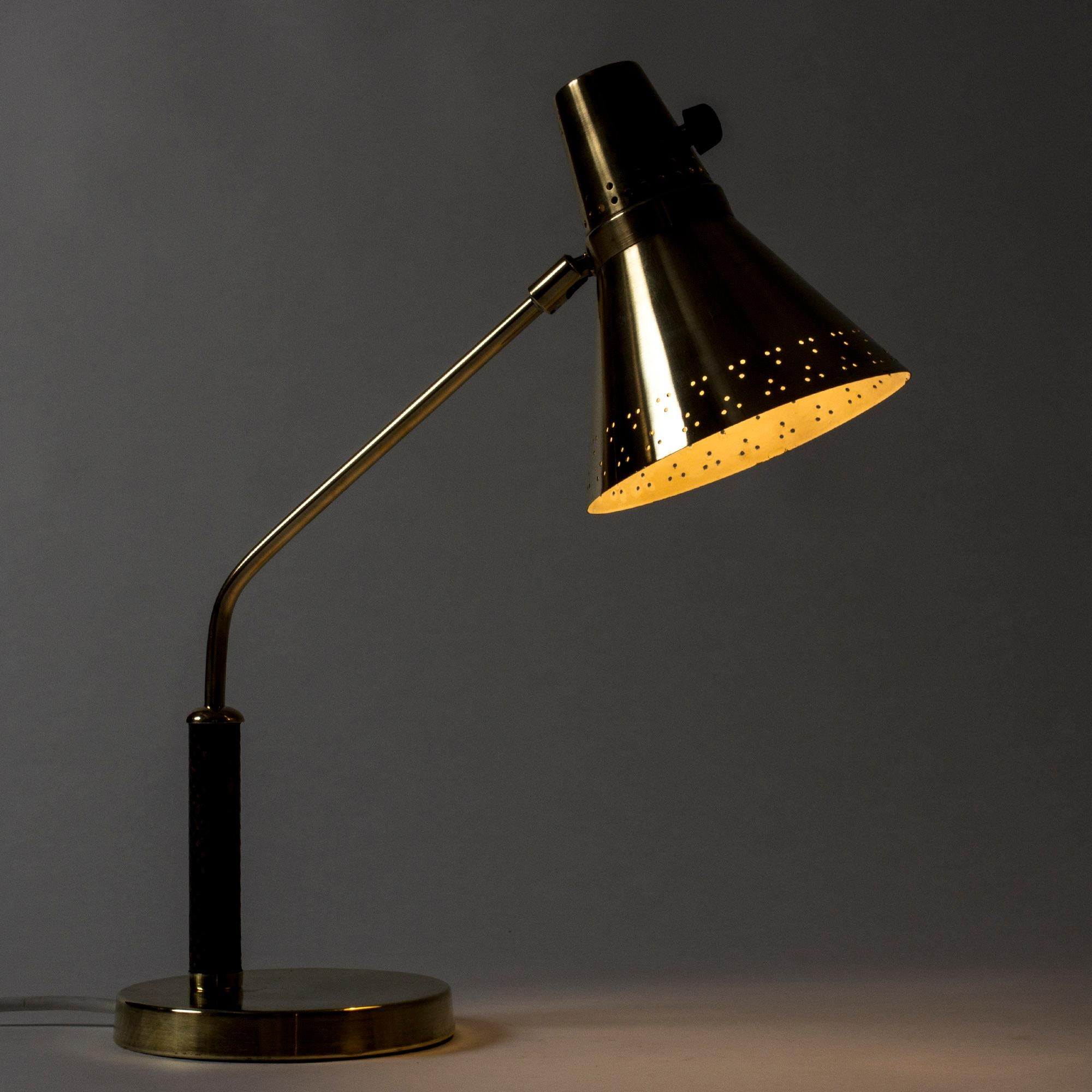 Very elegant desk or table lamp from E. Hansson & Co, made from brass. Shade with a perforated pattern that looks beautiful in the dark, snakeskin upholstered handle.