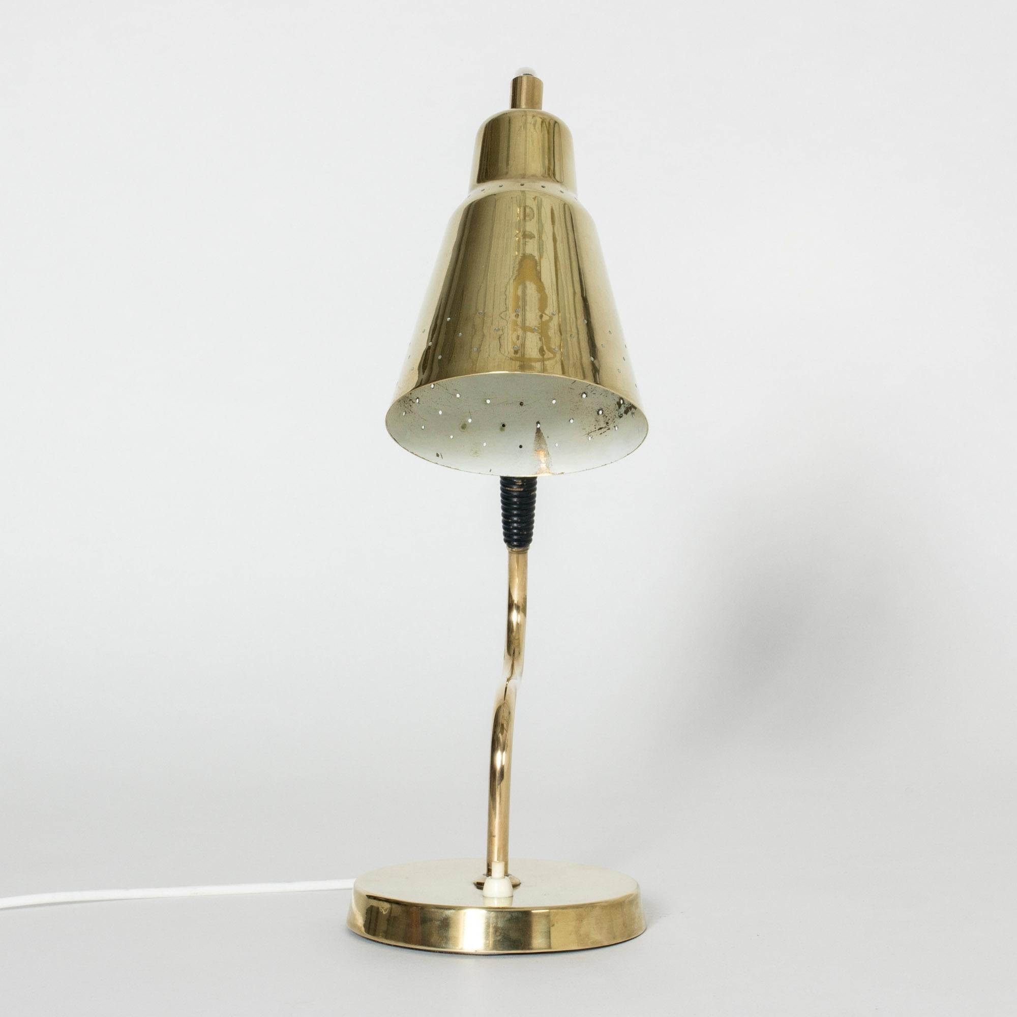 Elegant and buoyant brass table or desk lamp from Bergboms. Lampshade perforated with a pattern of small holes.