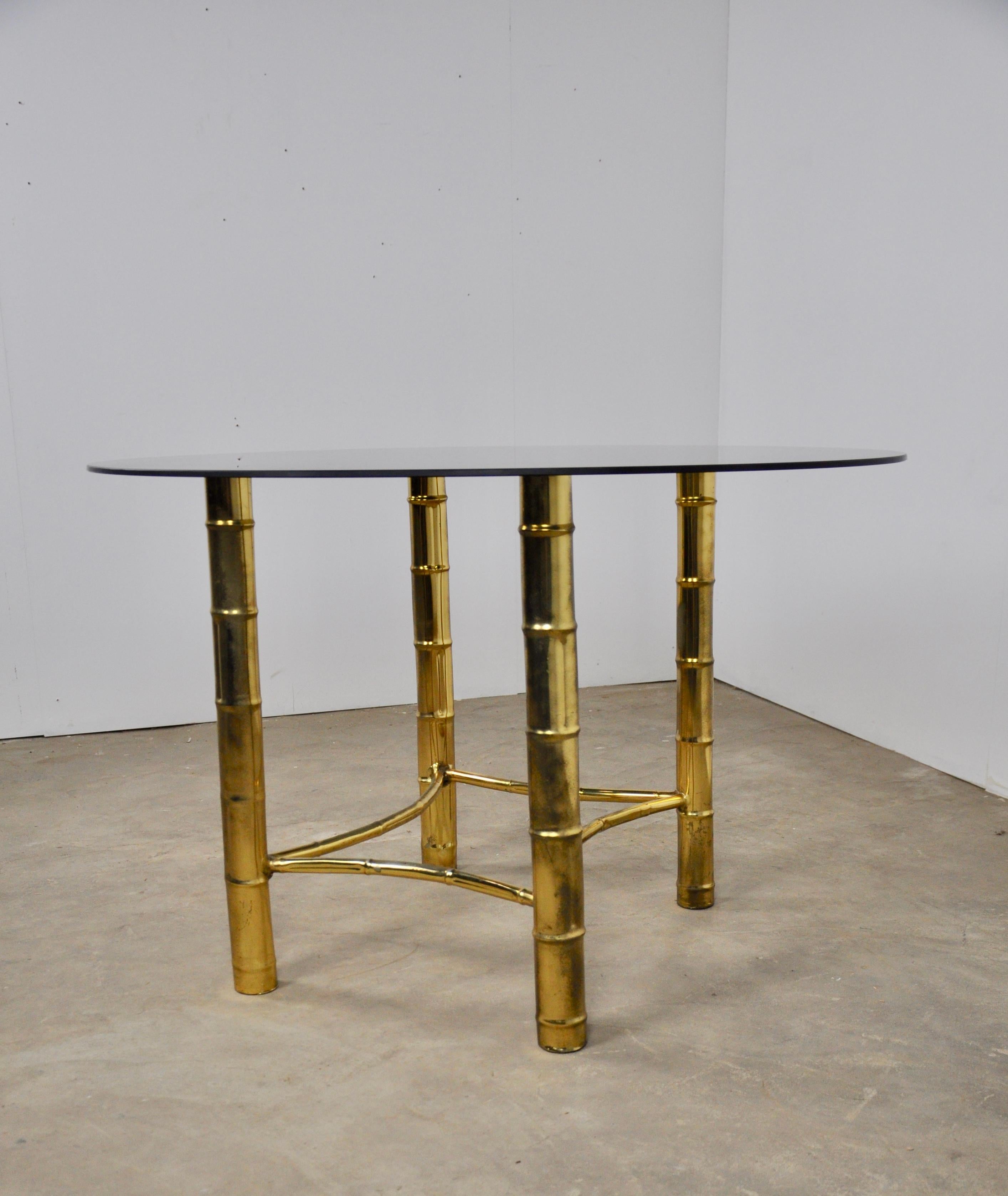 Brass table with 4 legs in bamboo imitation. The shelf is made of smoked glass.