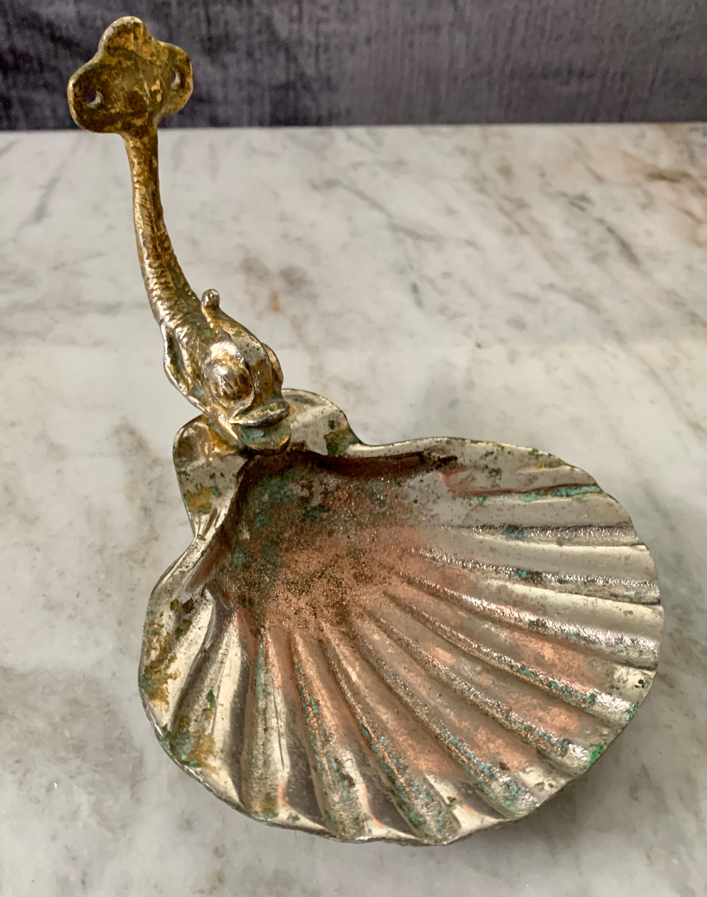 Brass vintage polished patinated dolphin soap dish, the dish has a wonderful patina from the midcentury. The piece easily sits on a counter, but also has holes to attach to a wall. The perfect decorator piece.