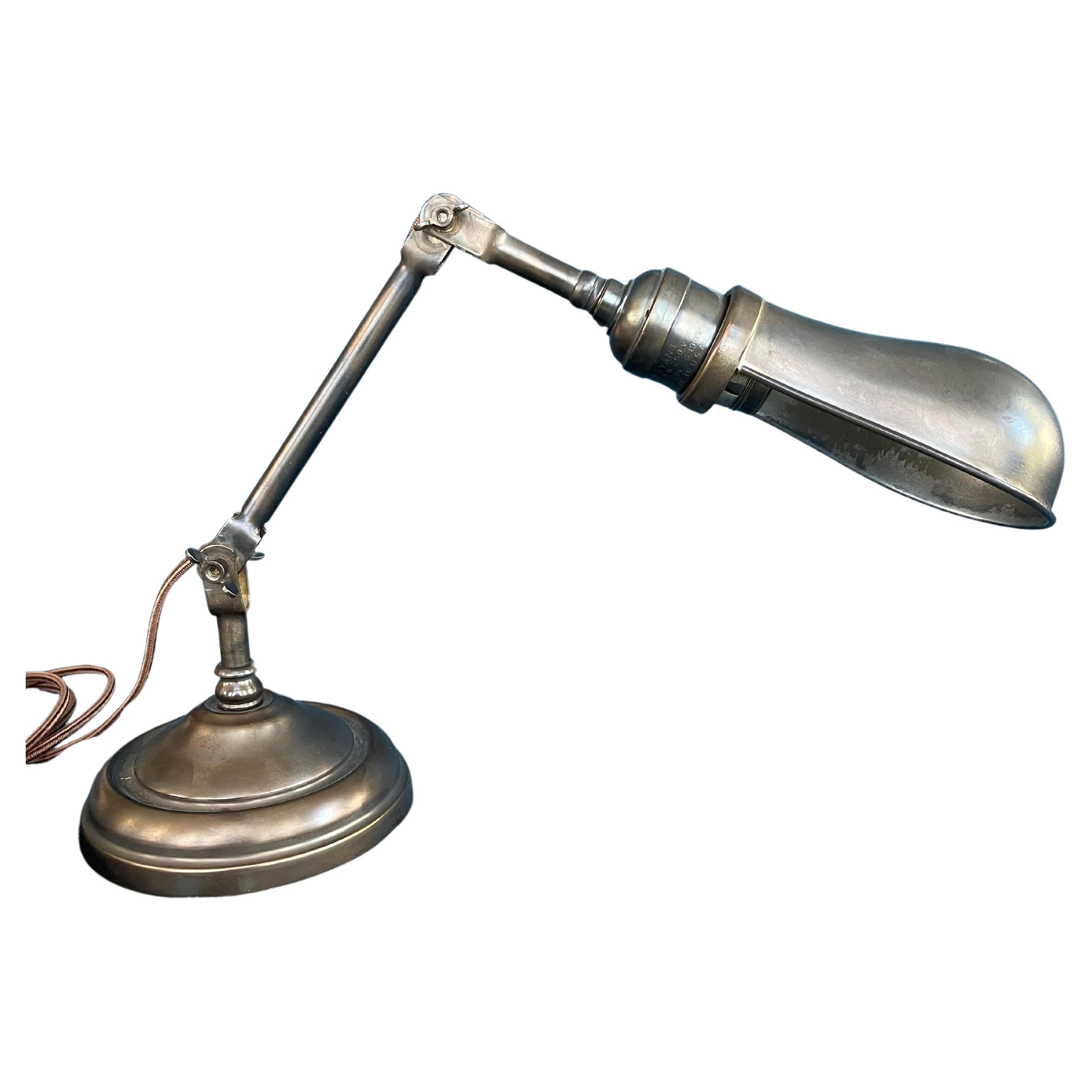  This most useful lamp was made by the Faries Lamp Co. This lamp has 2 points where the angle can be adjusted by just loosening the wing nuts in the 2 areas. The shade also swivels. It has an iron weight so that at any angle it won't tip over. Our