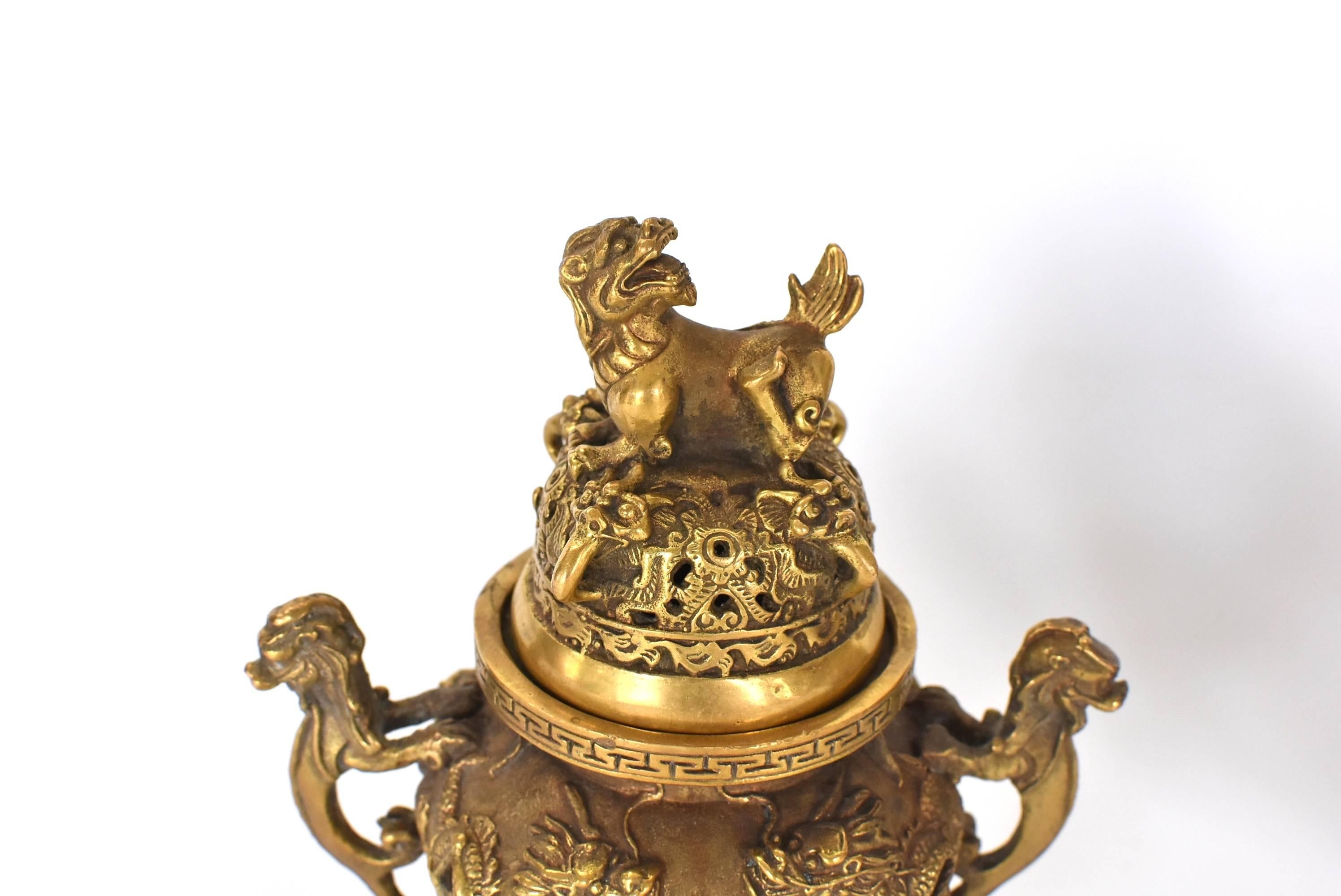 Exquisite incense burner features dragons all-over. Double dragons surrounding fire balls symbolize the vitality of life. Single dragon finial symbolizes leadership. Three mythical ox like creatures form the legs of the burner. Handles feature a