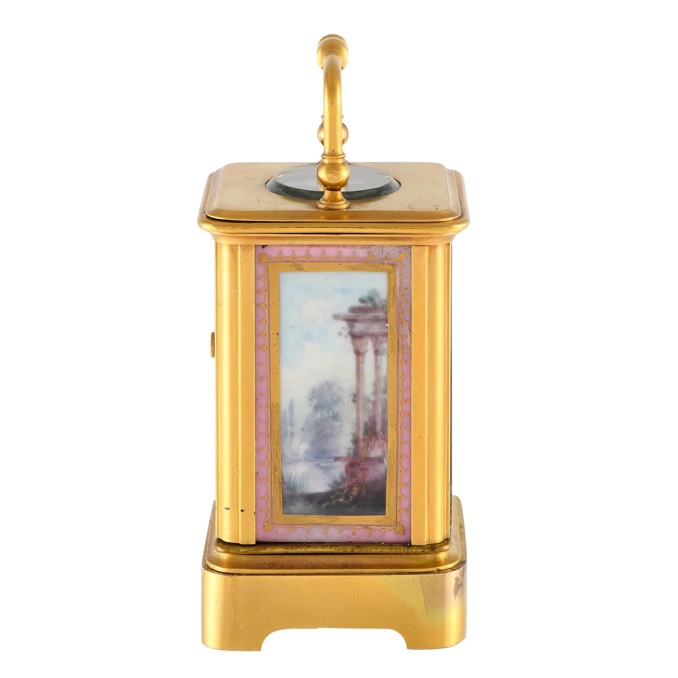 Track and remember the passage of time with this antique French carriage clock in brass and enamel. This miniature table clock features an oval glass escapement window on top, with an elegant handle. Hand-painted scenes are seen on the porcelain