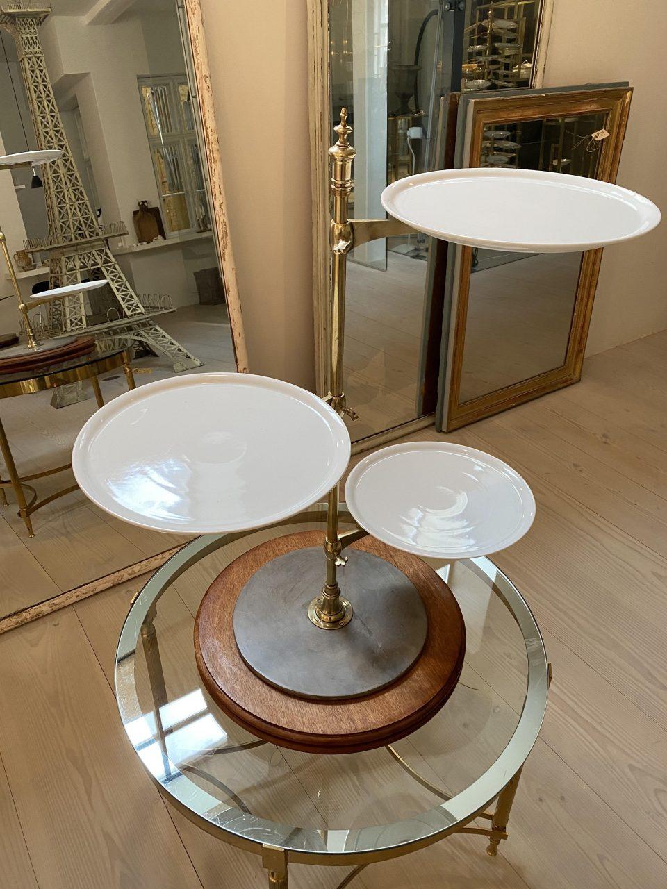 Beautiful and high quality brass stand /shelving, with a sleek elegant look. On a handsome round wooden base. Each of the round disc shelves are white porcelain plates. Wonderful piece for display purposes. An old French confectionary étagère from a