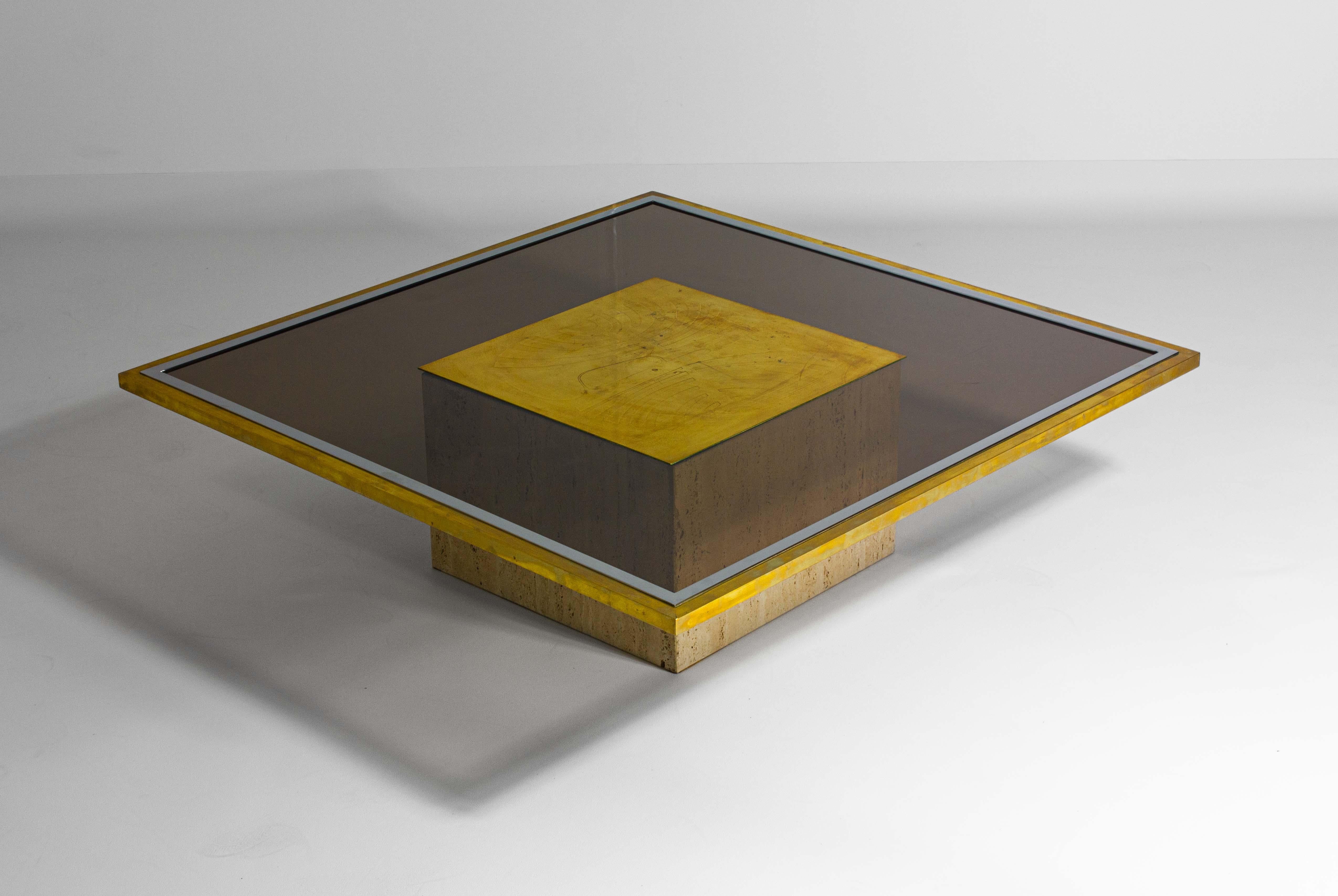 This etched table is framed by a lavish combination of brass and chrome edges, which reflect the light and add a touch of opulence to the piece. This metallic trim not only provides a striking contrast to the smoked glass but also pays homage to the