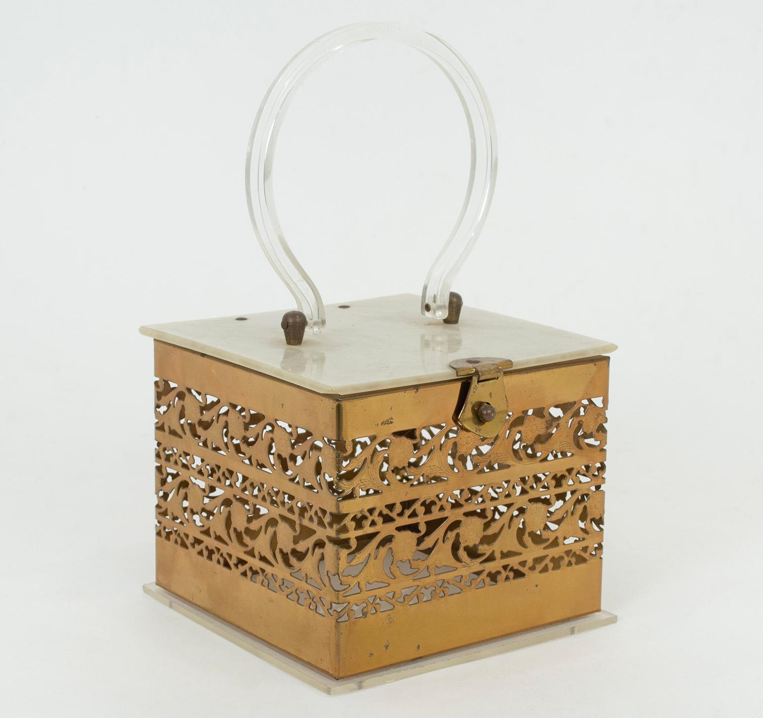 Simultaneously delicate and sturdy, this unusual box purse provides a glimpse of its contents via openwork filigree sides, while a clear Lucite platform base shows their entirety from beneath. A marbled Mother of Pearl hinged lid keeps items safe