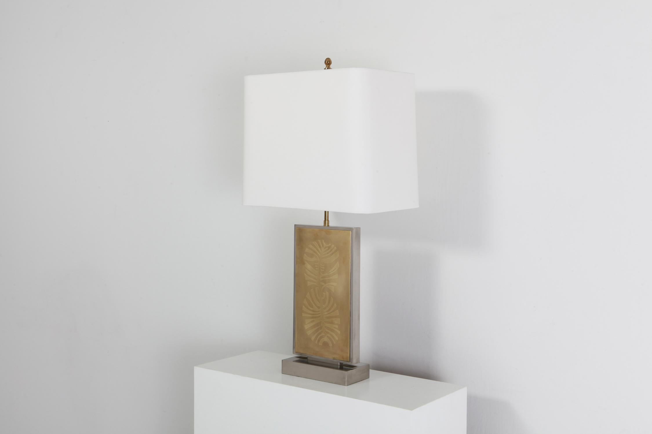 Hollywood regency; Lampada da tavolo; Base in resina nera; Opera d'arte incisa in ottone; Mid-Century Modern anni '70; Belgio; 

Questa lampada da tavolo Hollywood Regency è opera dell'artigiano belga Roger Vanhevel. Il pezzo è realizzato con un
