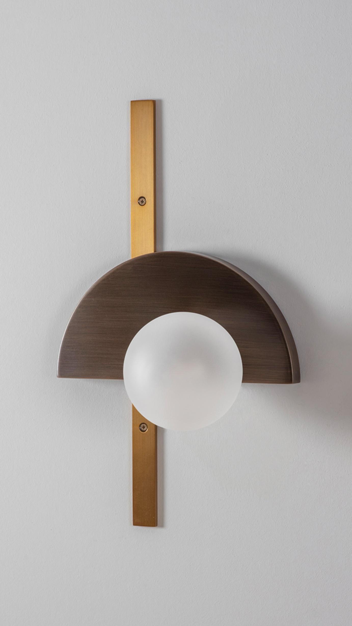 Brass Exhibition Wall Light by Square in Circle
Dimensions: W 25 x H 41.5 x D 15 cm
Materials: Brushed brass finish, antique bronze, white frosted glass globe.

The inspiration for this concept came from observing Joost Schmidt's Bauhaus Exhibition