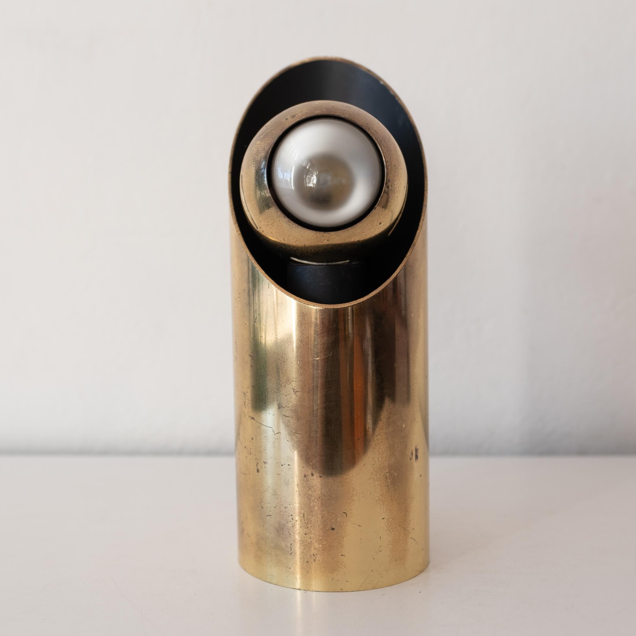 Solid brass eyeball spotlight lamp by Angelo Lelli for Arredoluce. Magnetic mount allows the eyeball spotlight to be rotated. Substantial heavy build. Dimmer switch and wired for US. Great original patina. 